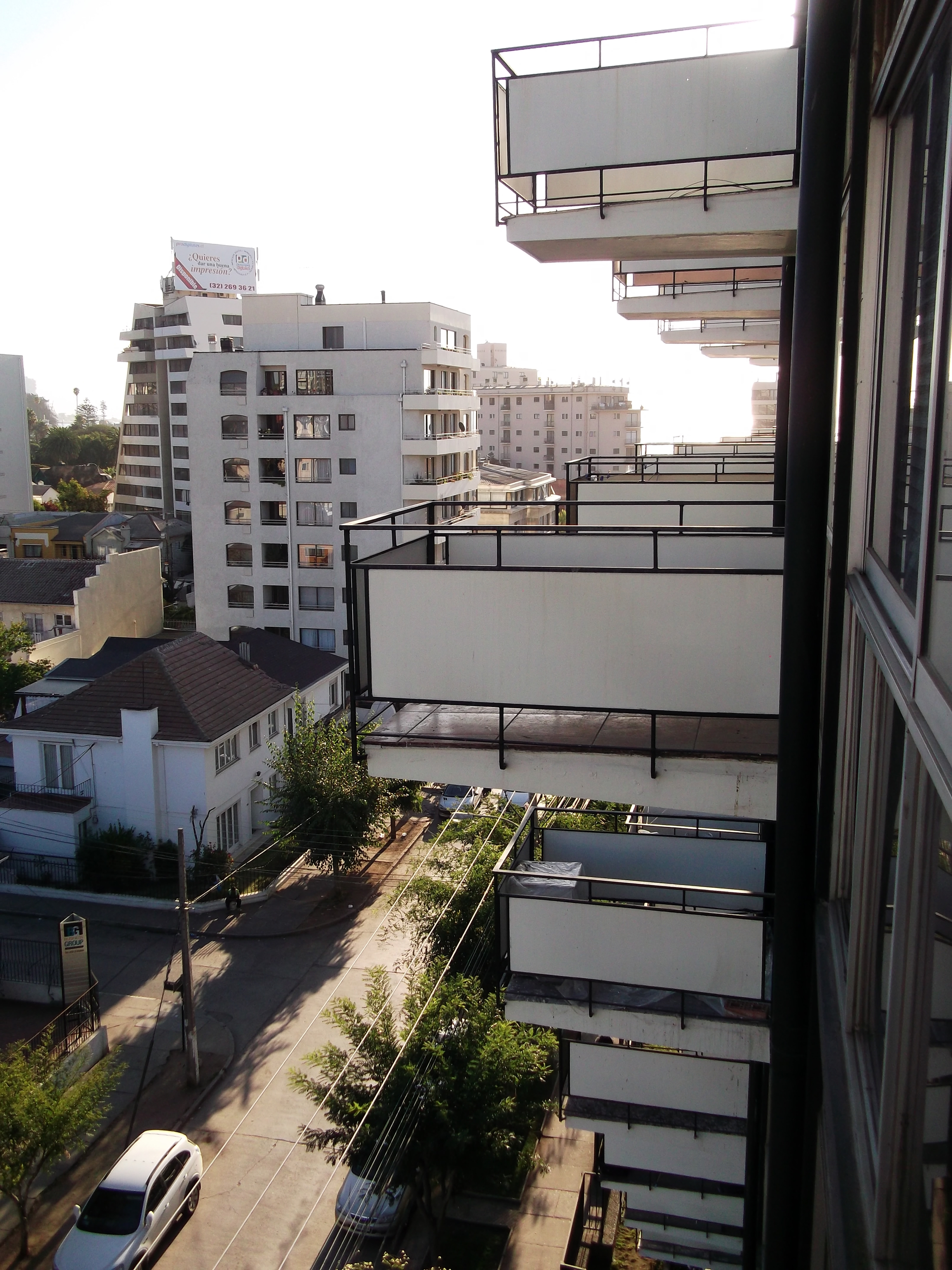 View from a balcony showing staggered concrete balconies and planted terraces at ground level
