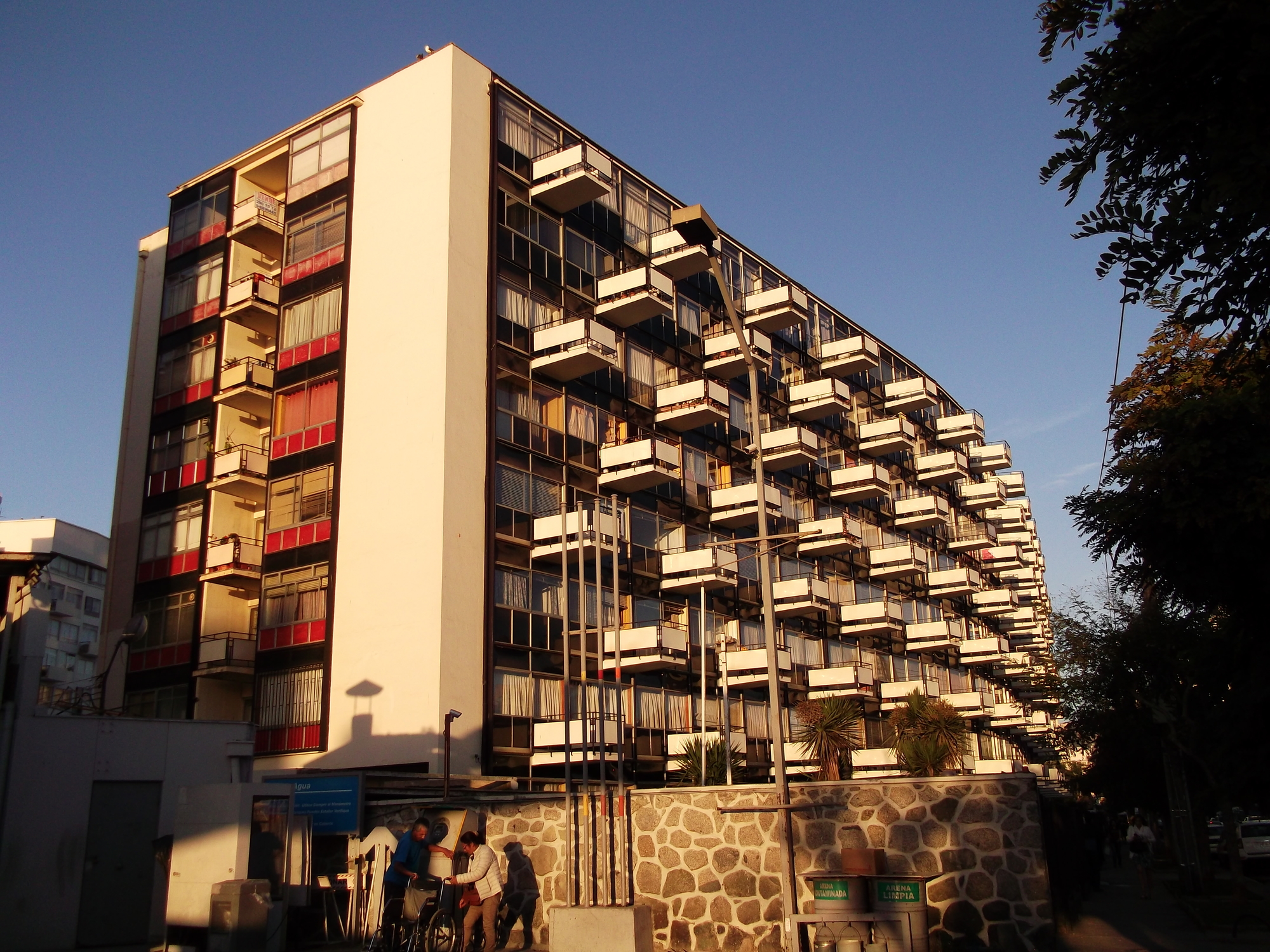 Corner view of the tower with projecting balconies and stone base wall at golden hour