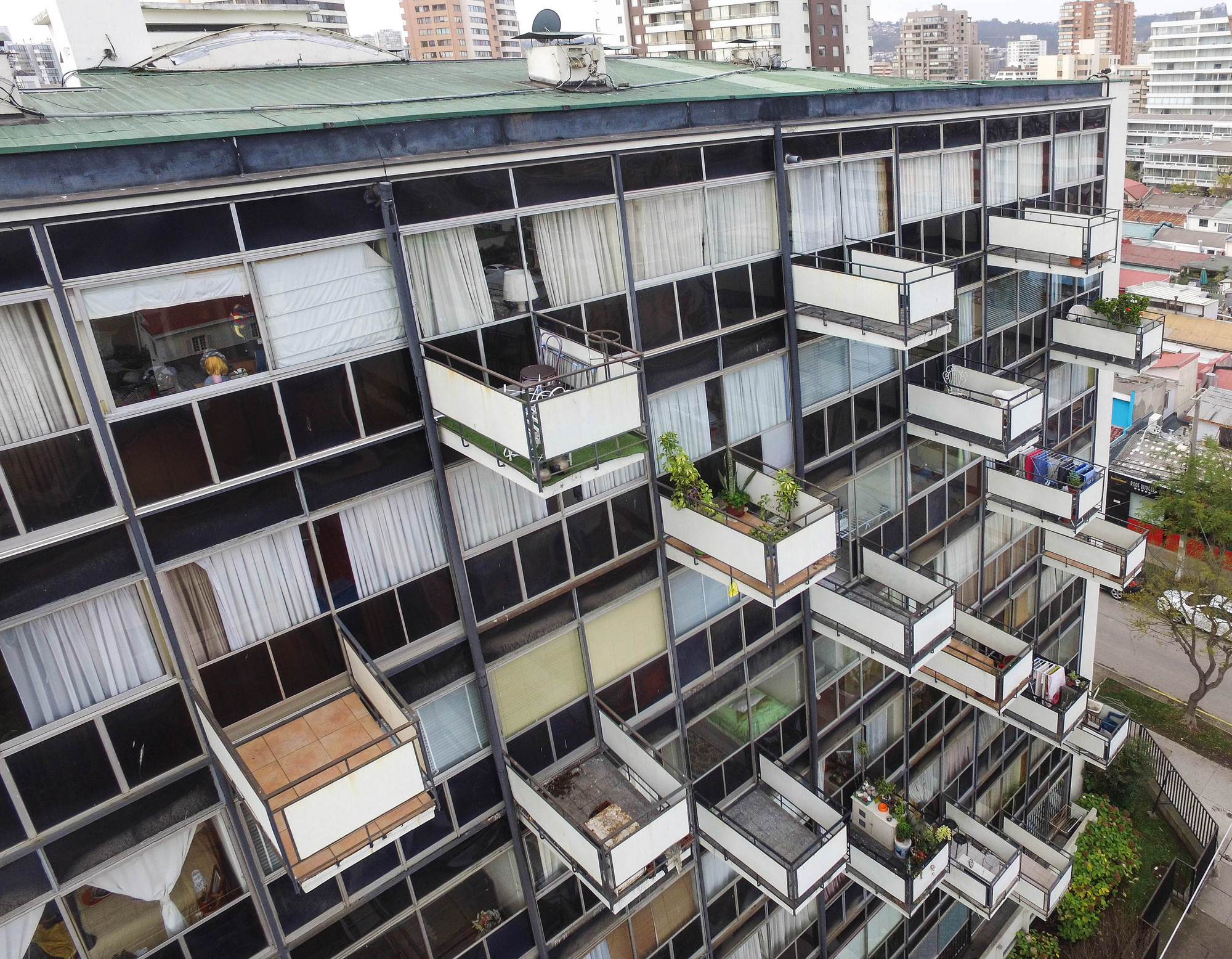 Close-up of the facade showing individual balconies with sliding glass panels and curtains