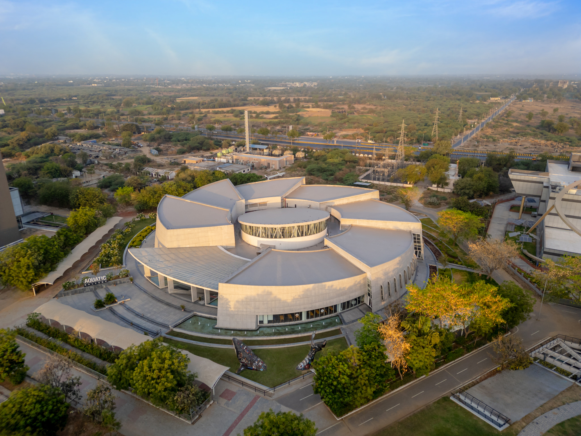 Drone view of the radial roof petals extending from a central glazed drum in afternoon light