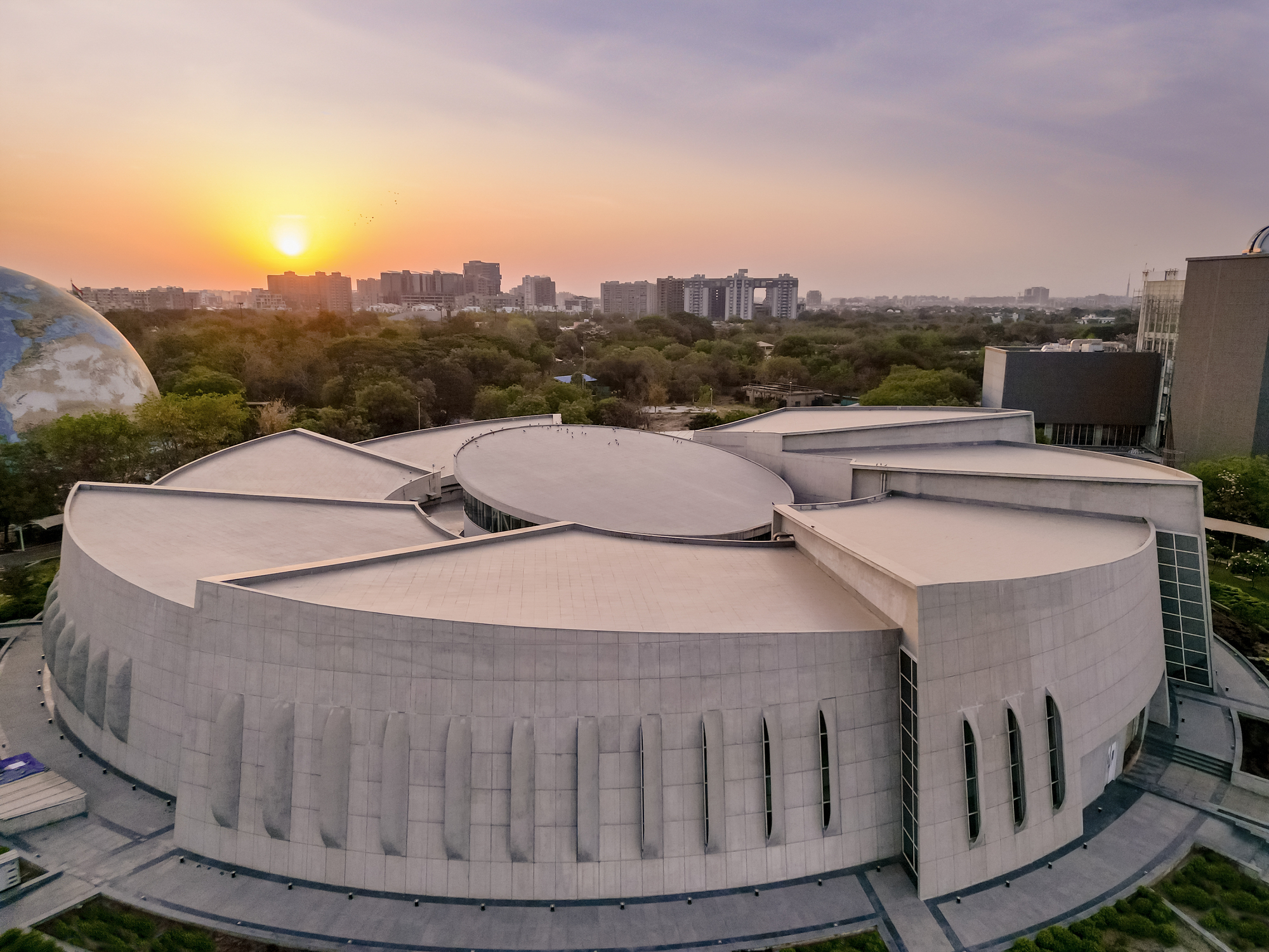 Aerial view of the cloverleaf-shaped roof with vertical window slits at sunset