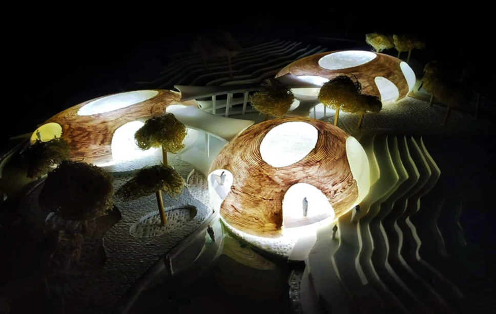 Illuminated architectural model showing the river-inspired aquarium form merging with landscape and water.