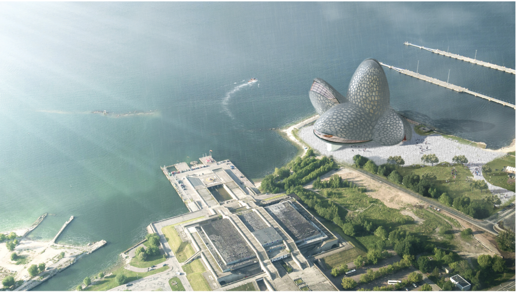 Aerial view of three bulbous domed volumes on a waterfront peninsula with a rectangular building complex nearby