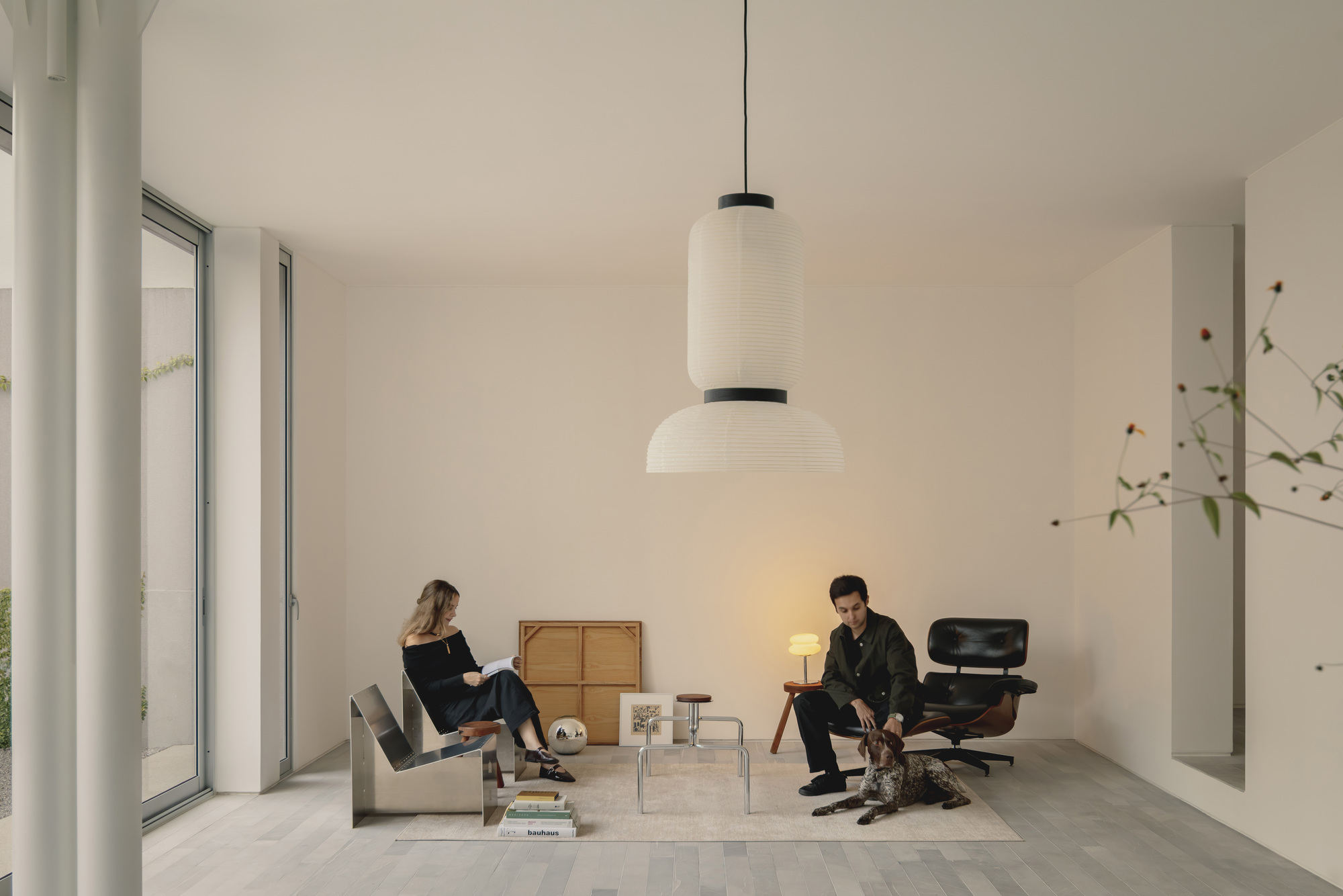 Living room with two seated figures beneath a layered pendant light fixture