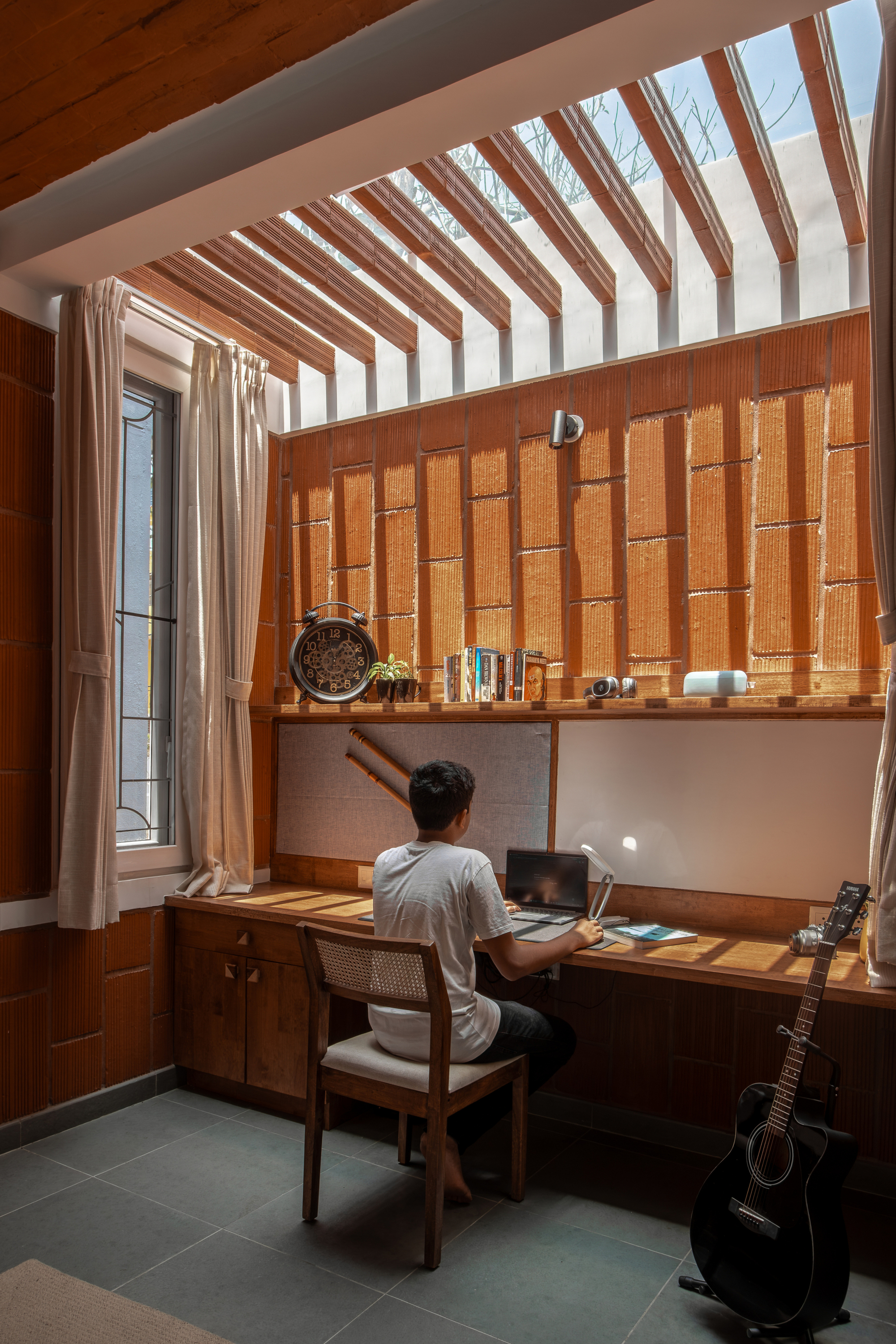 Study nook with timber ceiling slats and a person seated at the built-in desk