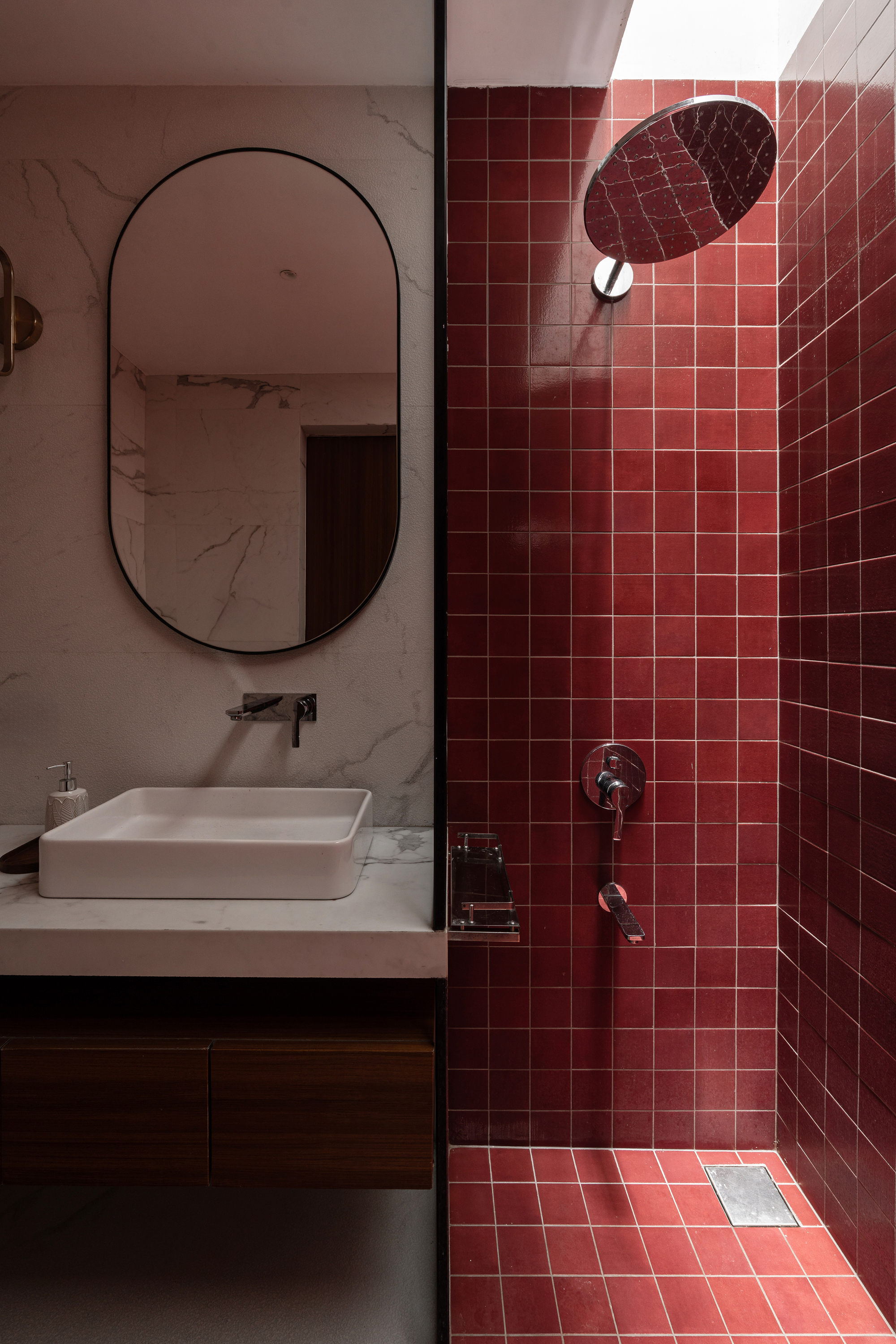 Bathroom with terracotta square tiles in the shower and marble-look vanity wall