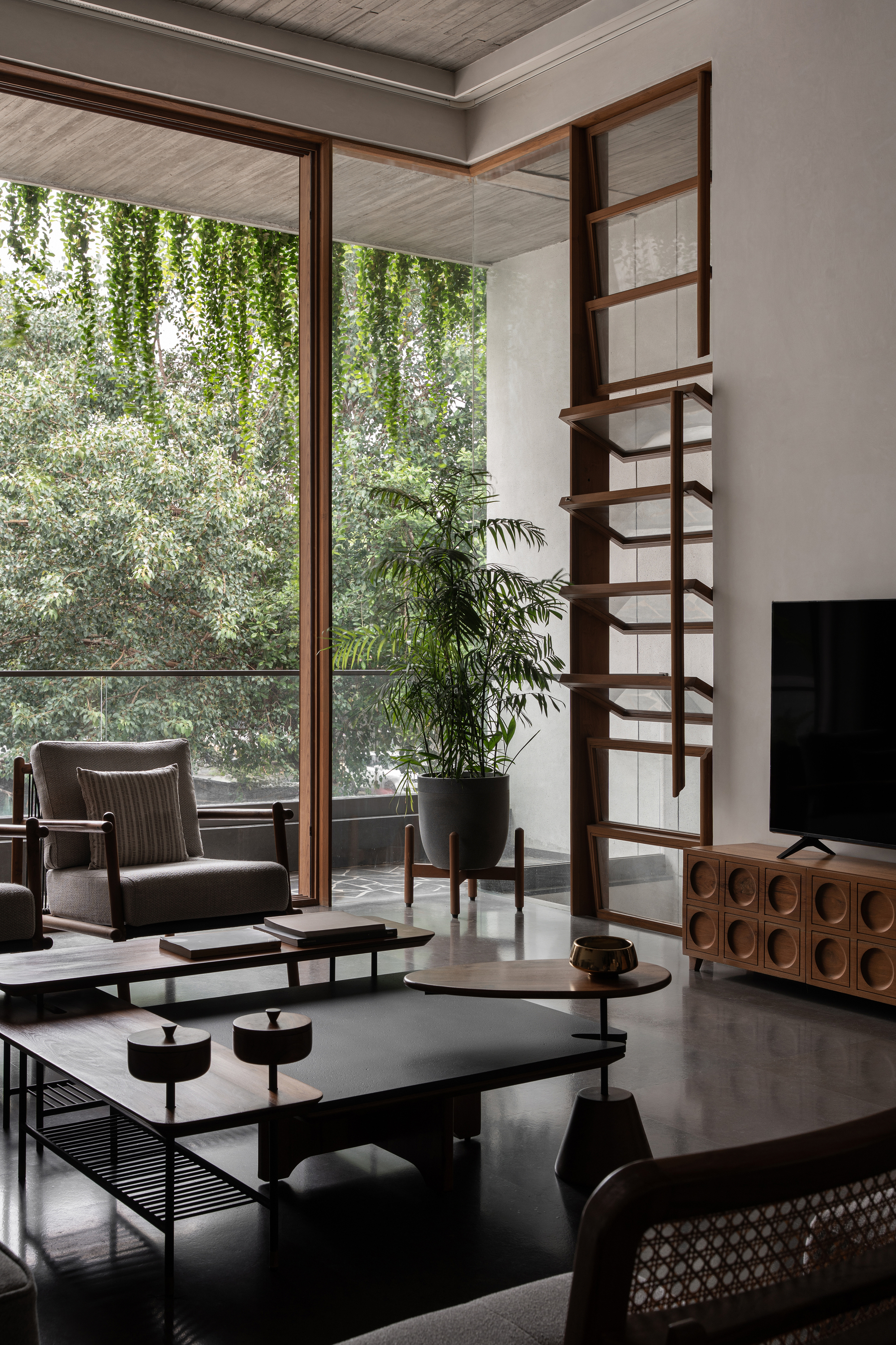 Timber-framed screen partition beside floor-to-ceiling glazing overlooking greenery
