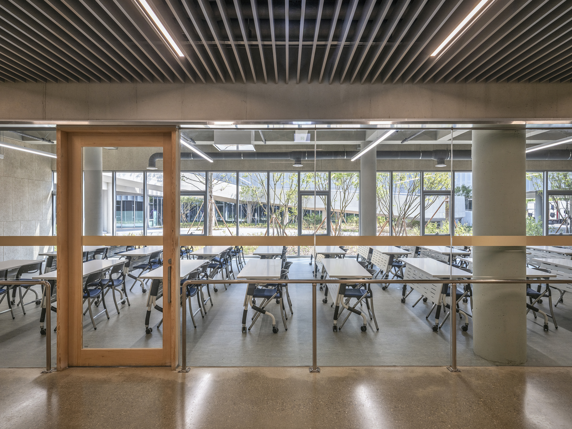 Dining area with timber-framed glass doors opening to a courtyard with bare trees