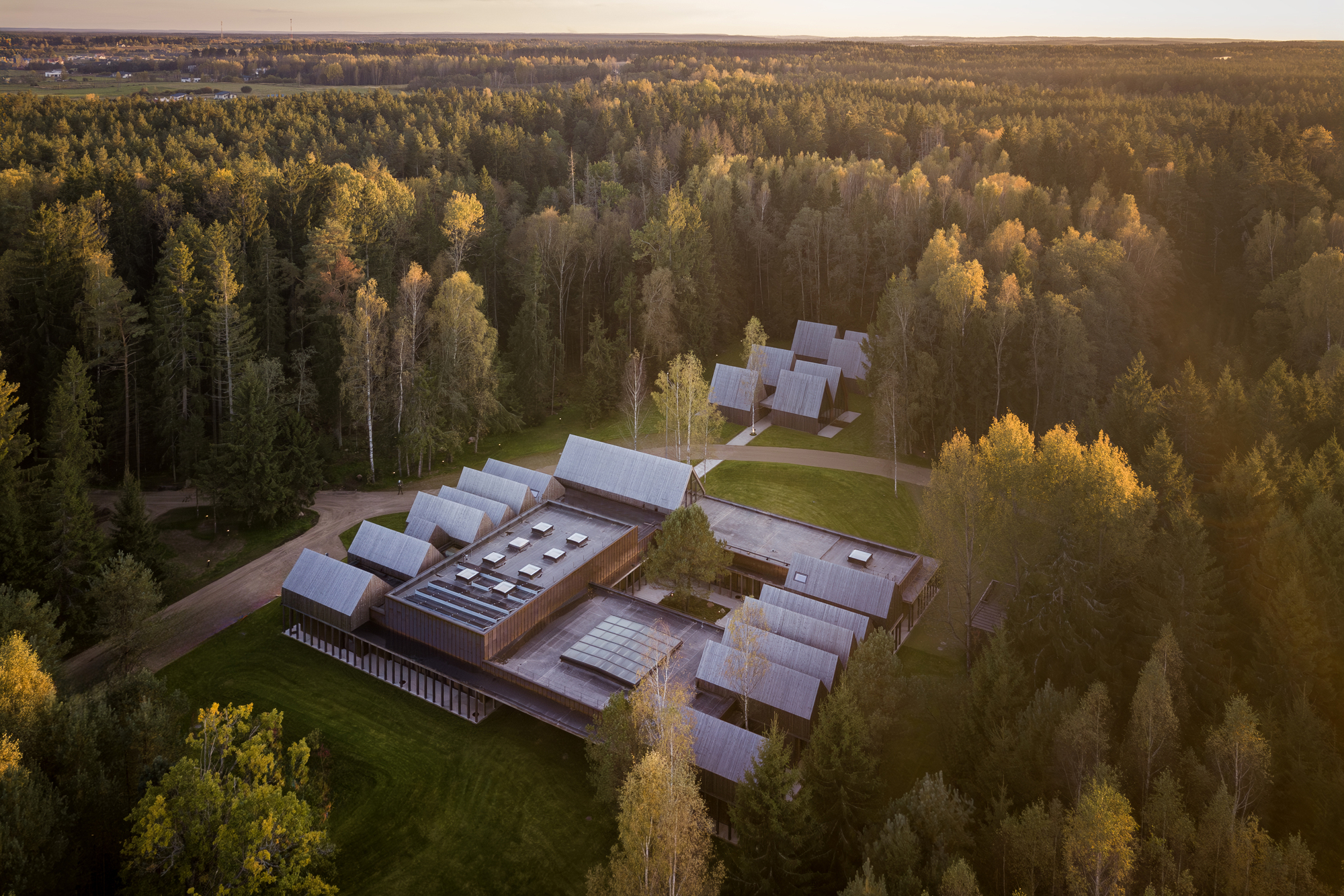 Aerial view of the compound surrounded by dense forest at golden hour