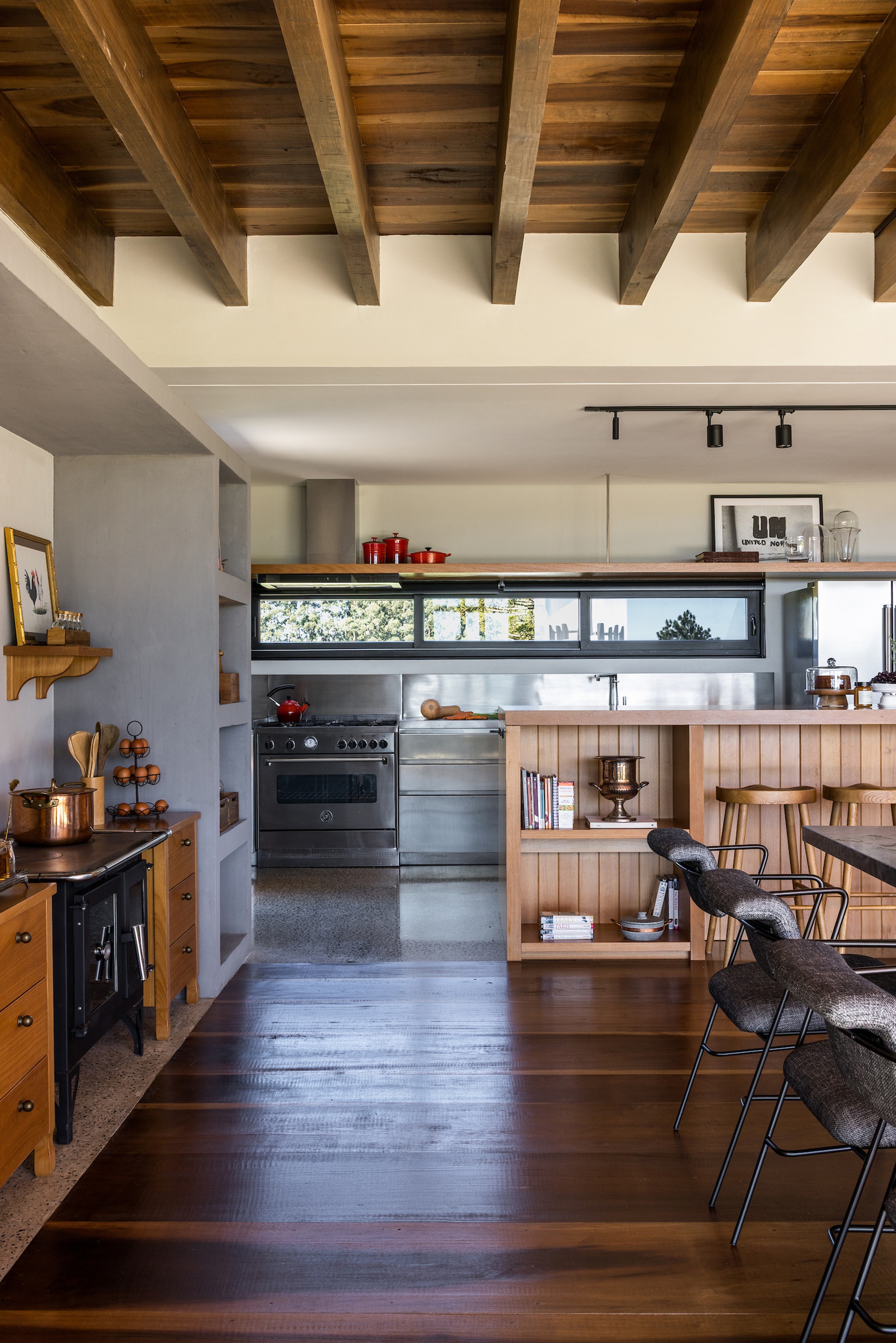 Kitchen with exposed timber ceiling beams and horizontal strip window above the countertop