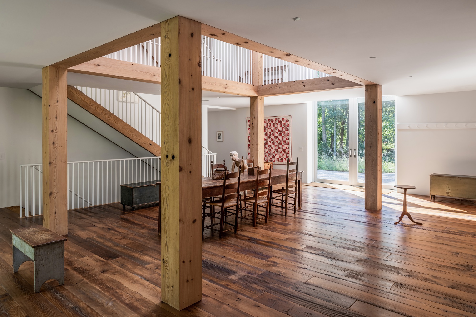 Open plan living space with exposed timber columns and reclaimed wood flooring under mezzanine