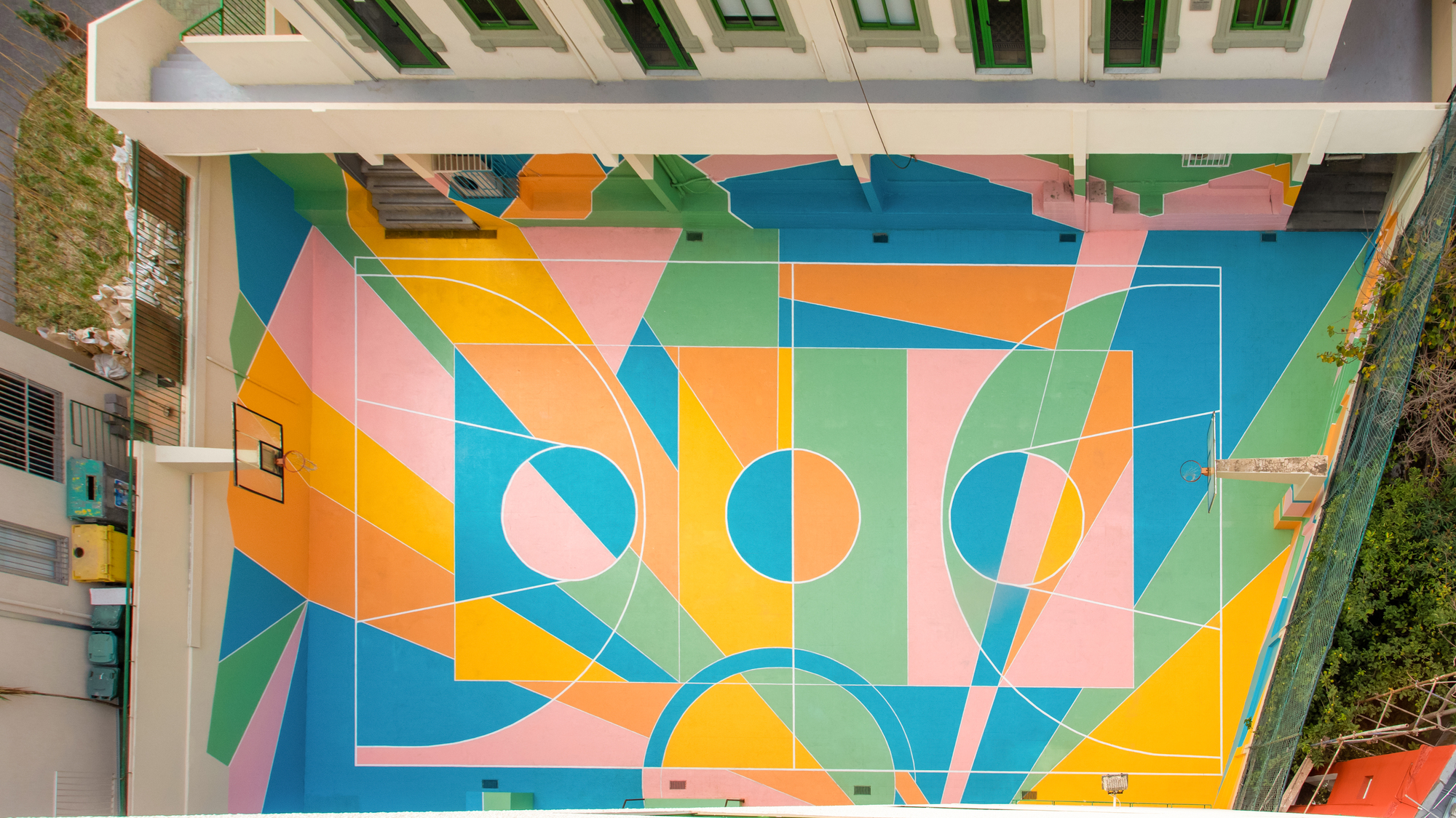 Aerial view of the basketball court showing intersecting pastel geometric patterns and white court markings