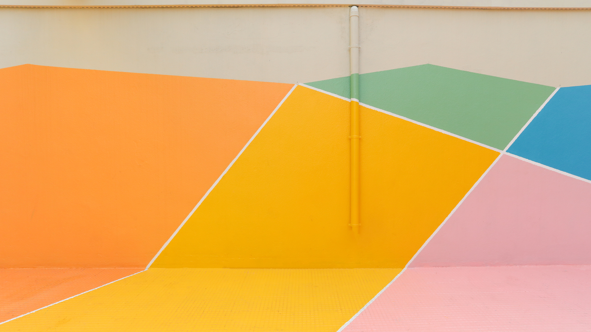 Close-up of the painted surface showing diagonal color fields in orange, yellow, pink, green and blue
