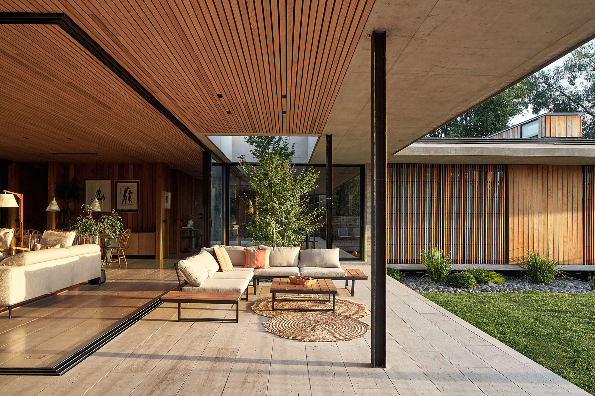 Interior courtyard framed by timber soffits and slender columns with a potted tree