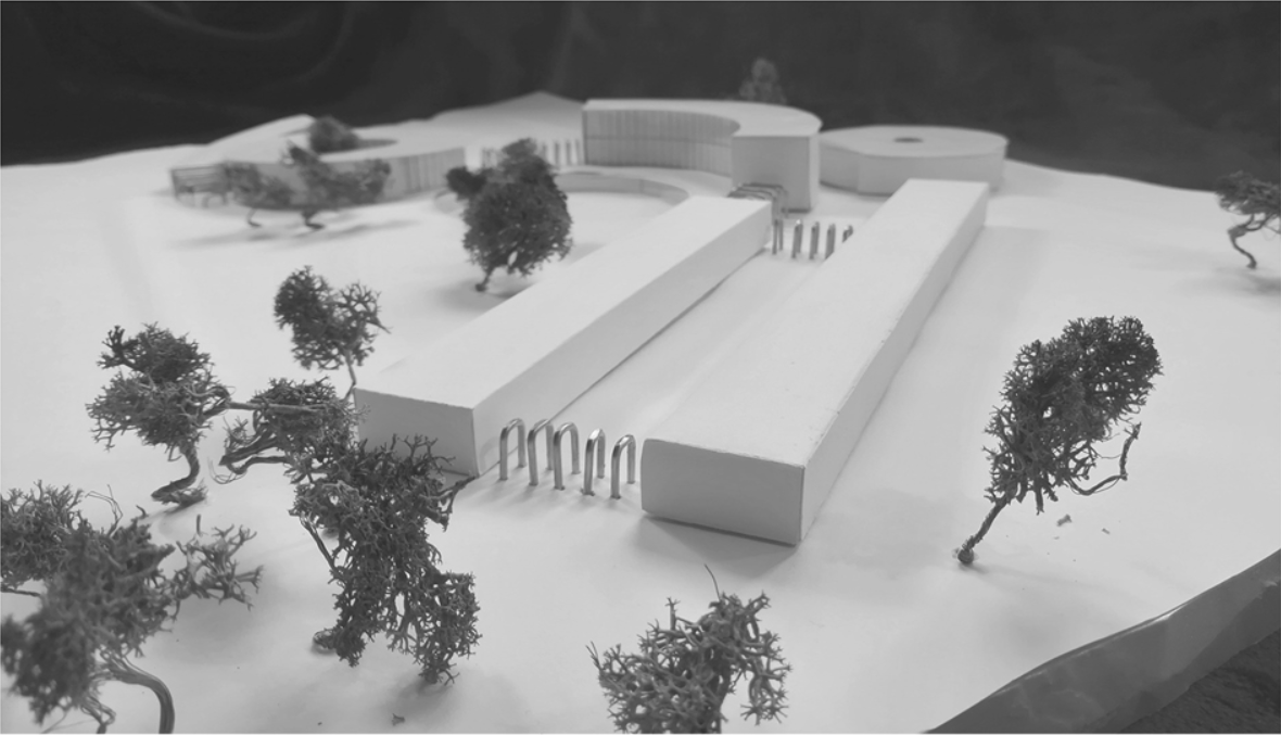 Physical model showing curving volumes with timber colonnade connecting rectilinear buildings through landscape