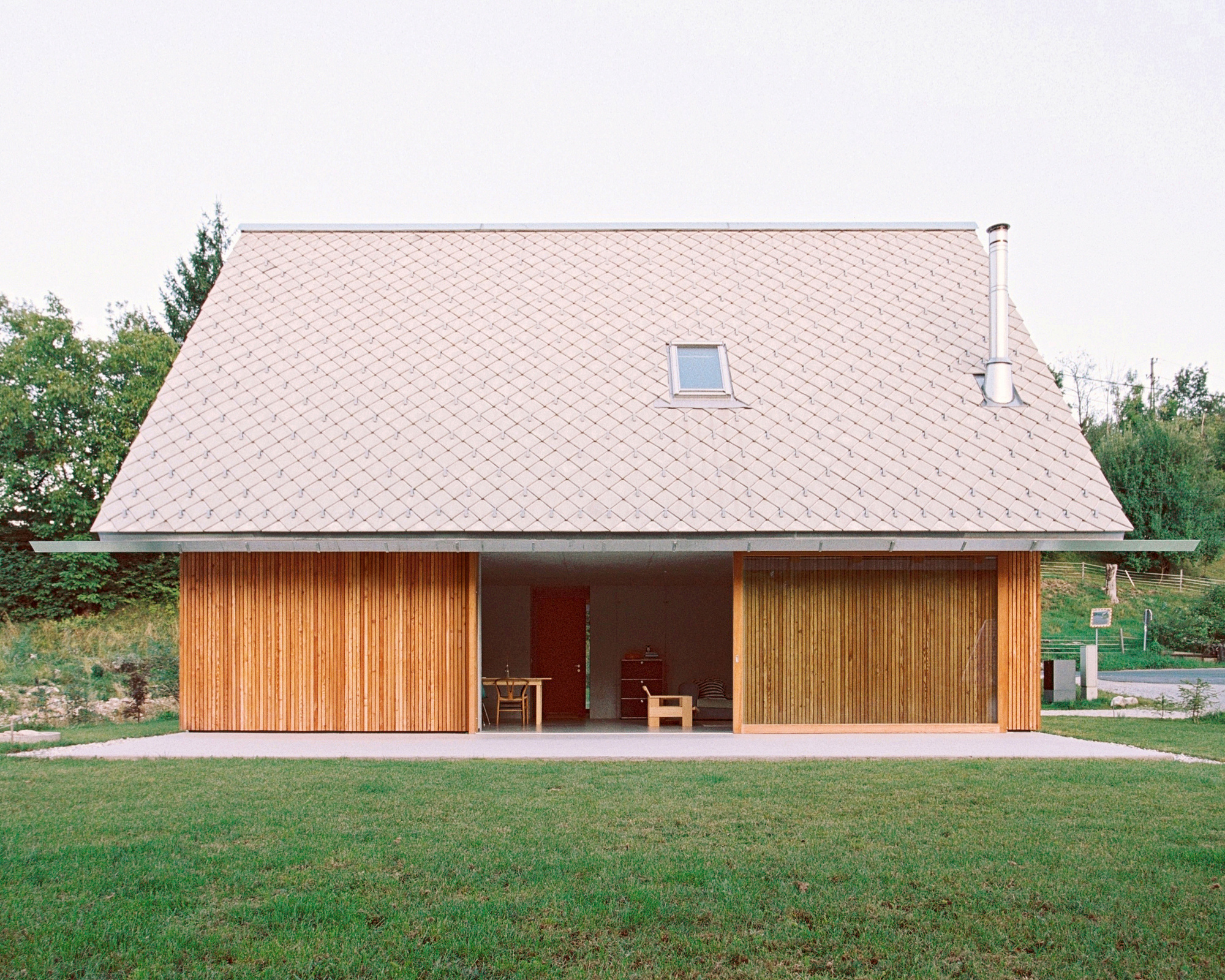 Facade view of the deeply recessed entrance loggia framed by timber shutters on both sides