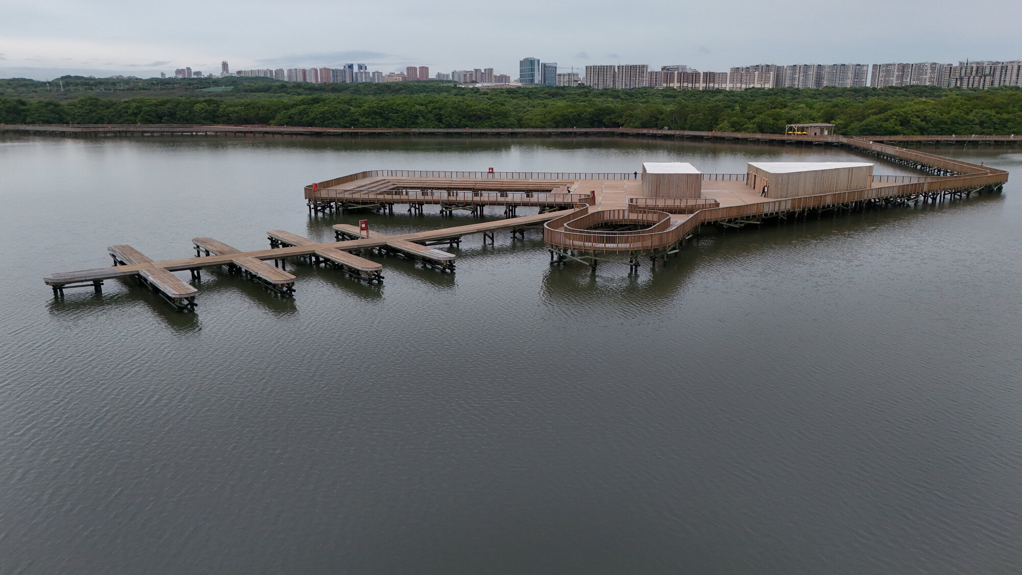 Aerial view of the waterfront boardwalk with pavilions and pier extensions under overcast sky