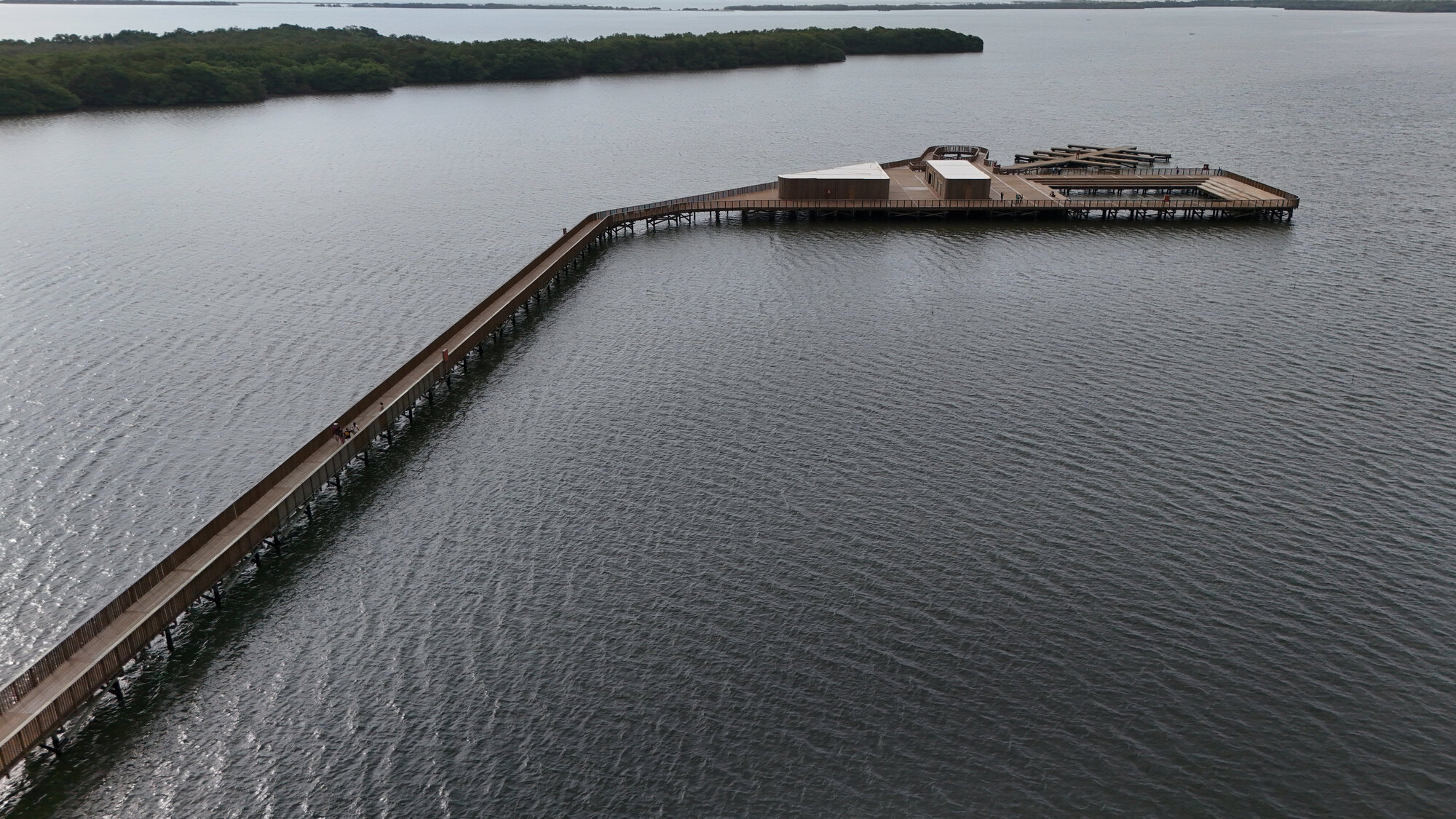 Aerial view of the timber boardwalk extending across the water toward a circular viewing platform