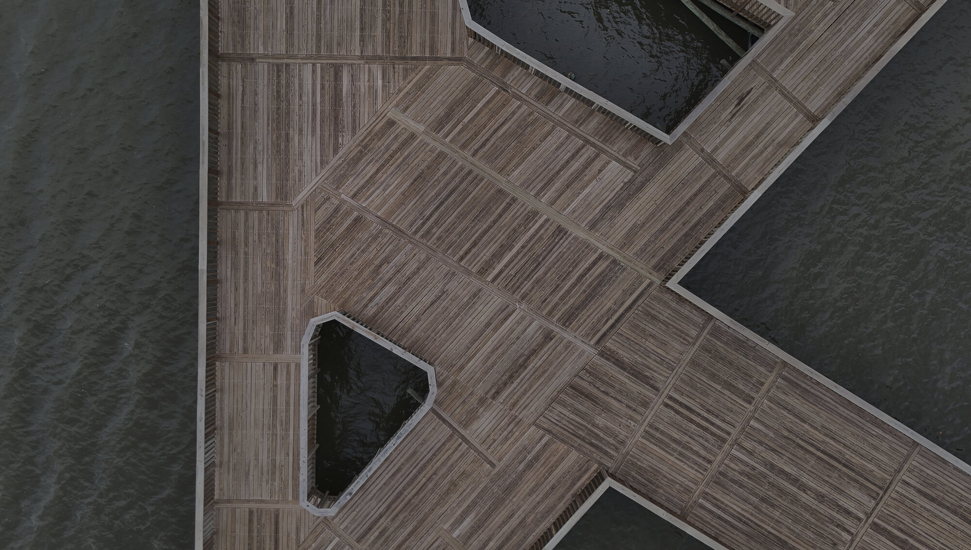 Drone view showing the timber deck sections with triangular and rectangular openings over water