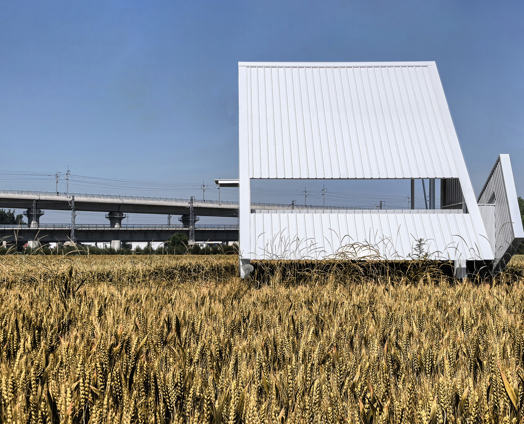 White metal-clad volume with angled roof and rectangular window opening beside a concrete viaduct