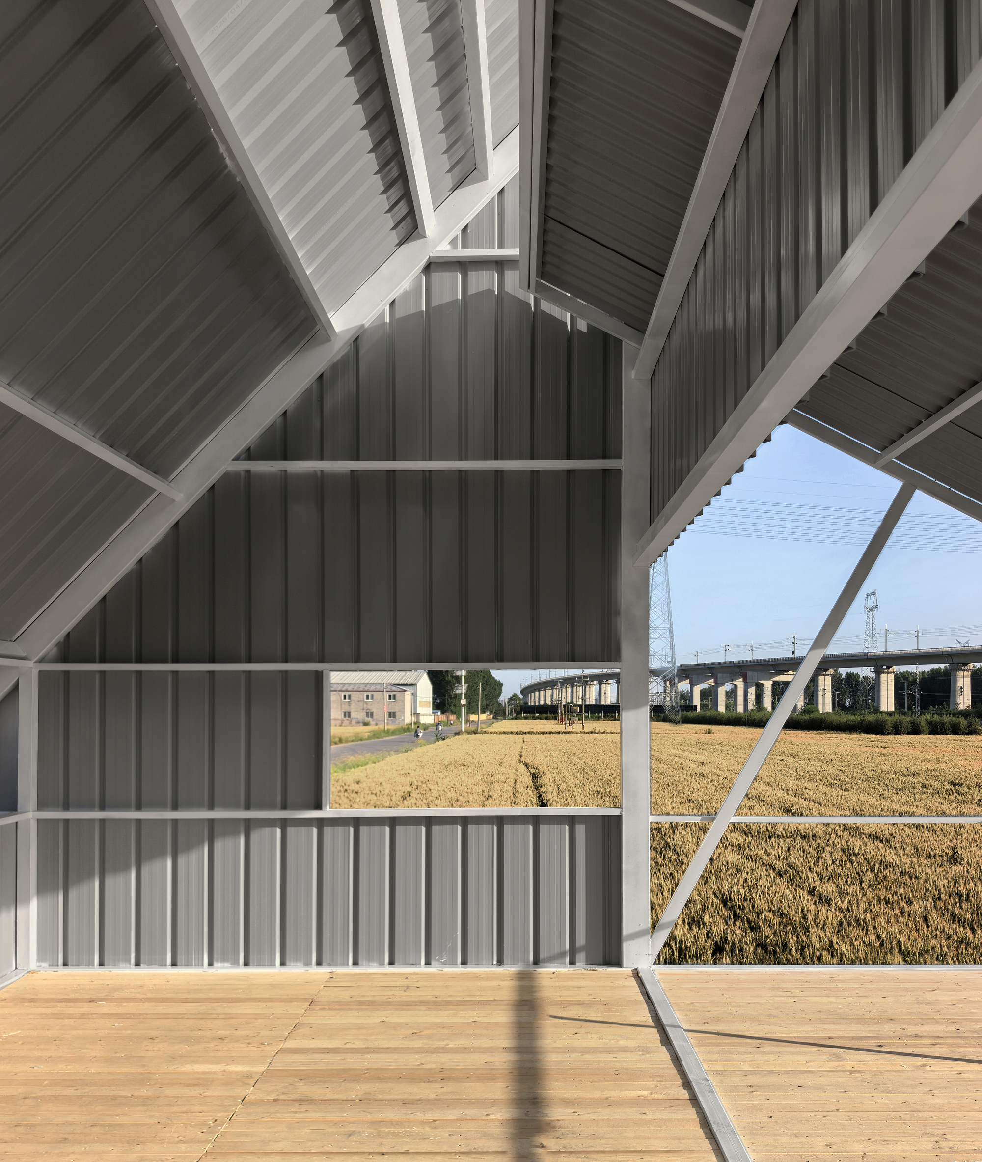 Interior view under the exposed pitched roof with white steel frame and plywood decking