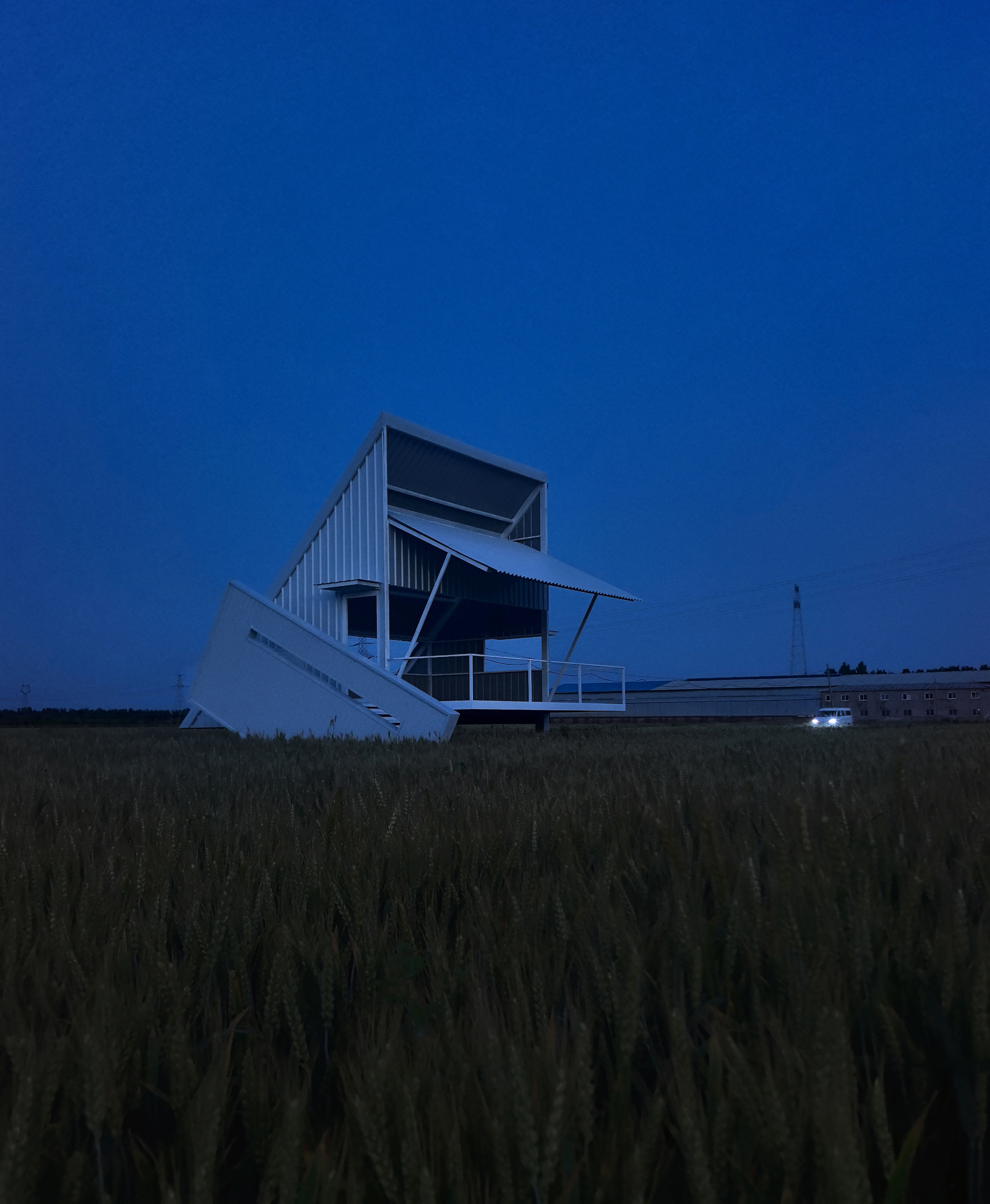 Metal observation structure with angled staircase and platform silhouetted against deep blue twilight sky