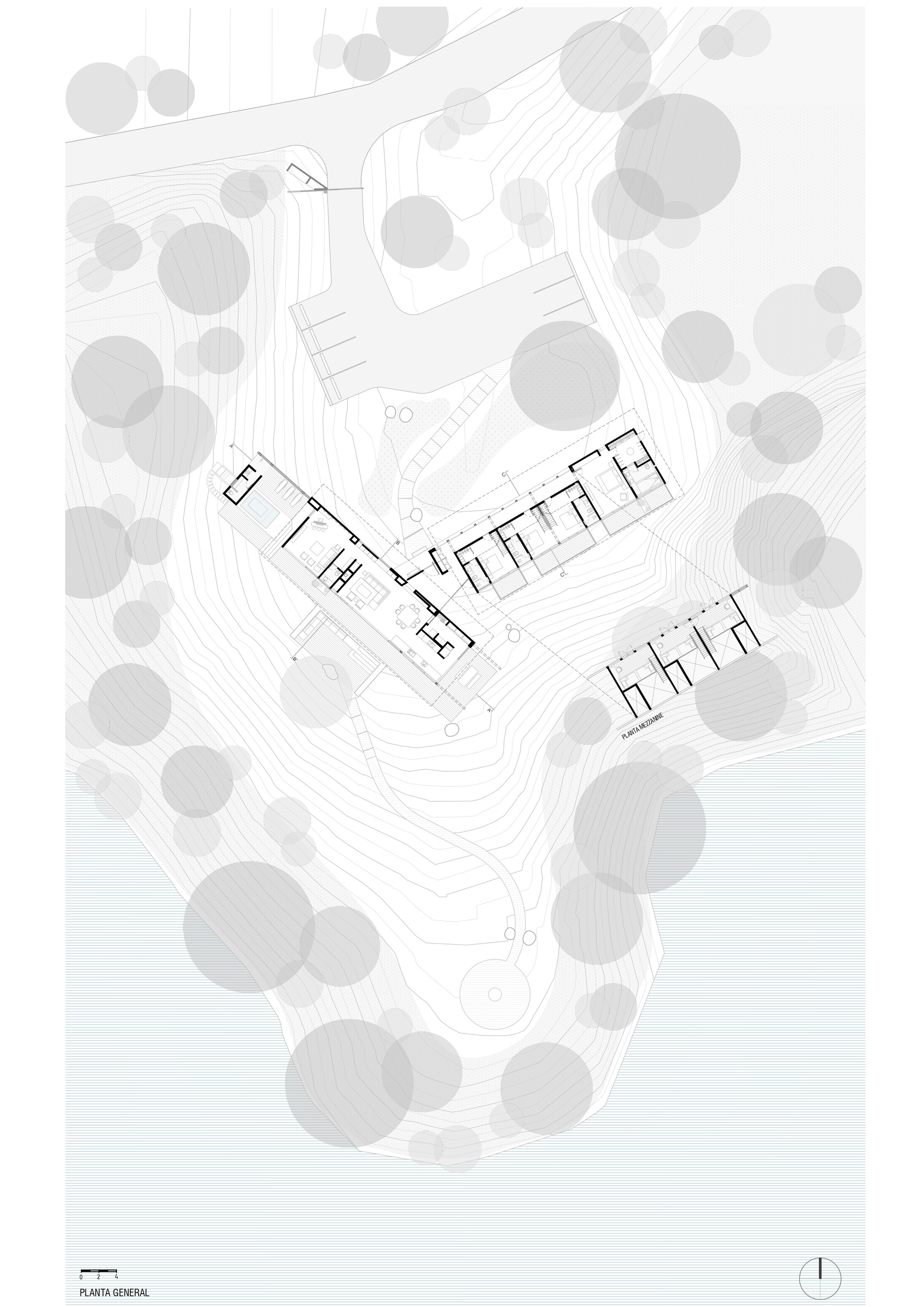 Floor plan drawing showing two linear wings with interior room divisions nestled in a wooded hillside