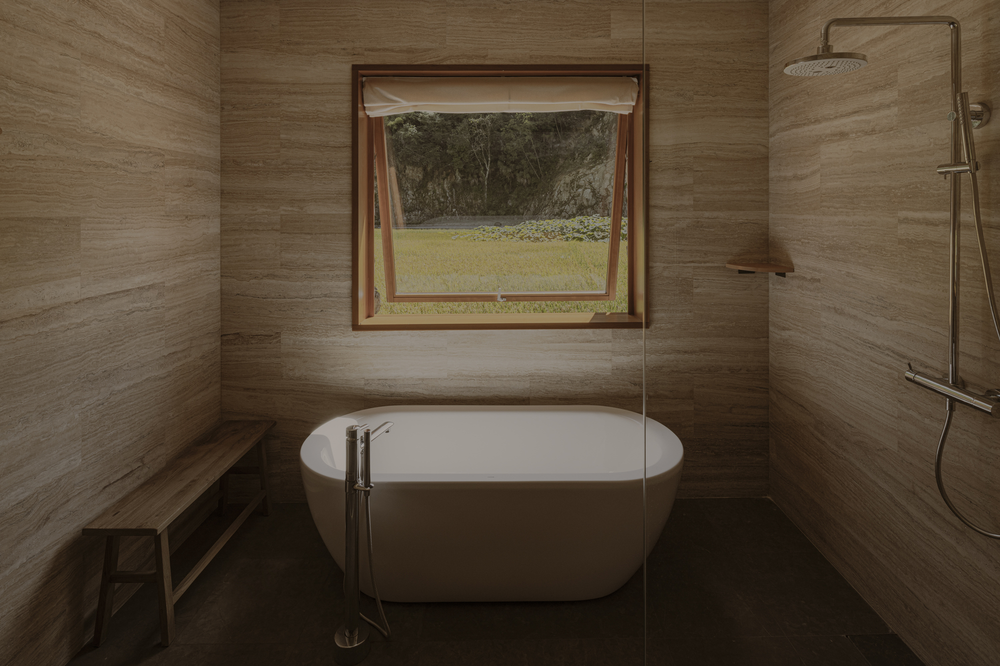 Bathroom with freestanding tub, wood-grain tile walls and casement window opening to green lawn