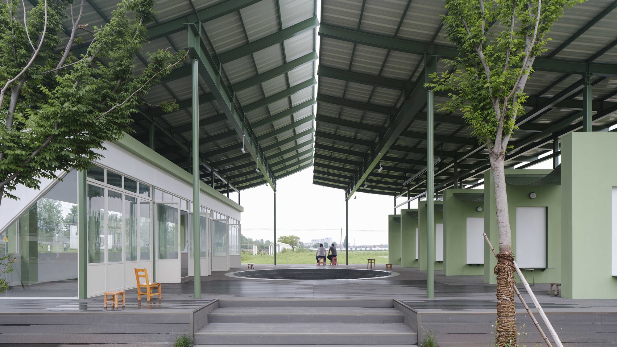 Timber deck steps leading to central platform under solar canopy with visitors in distance