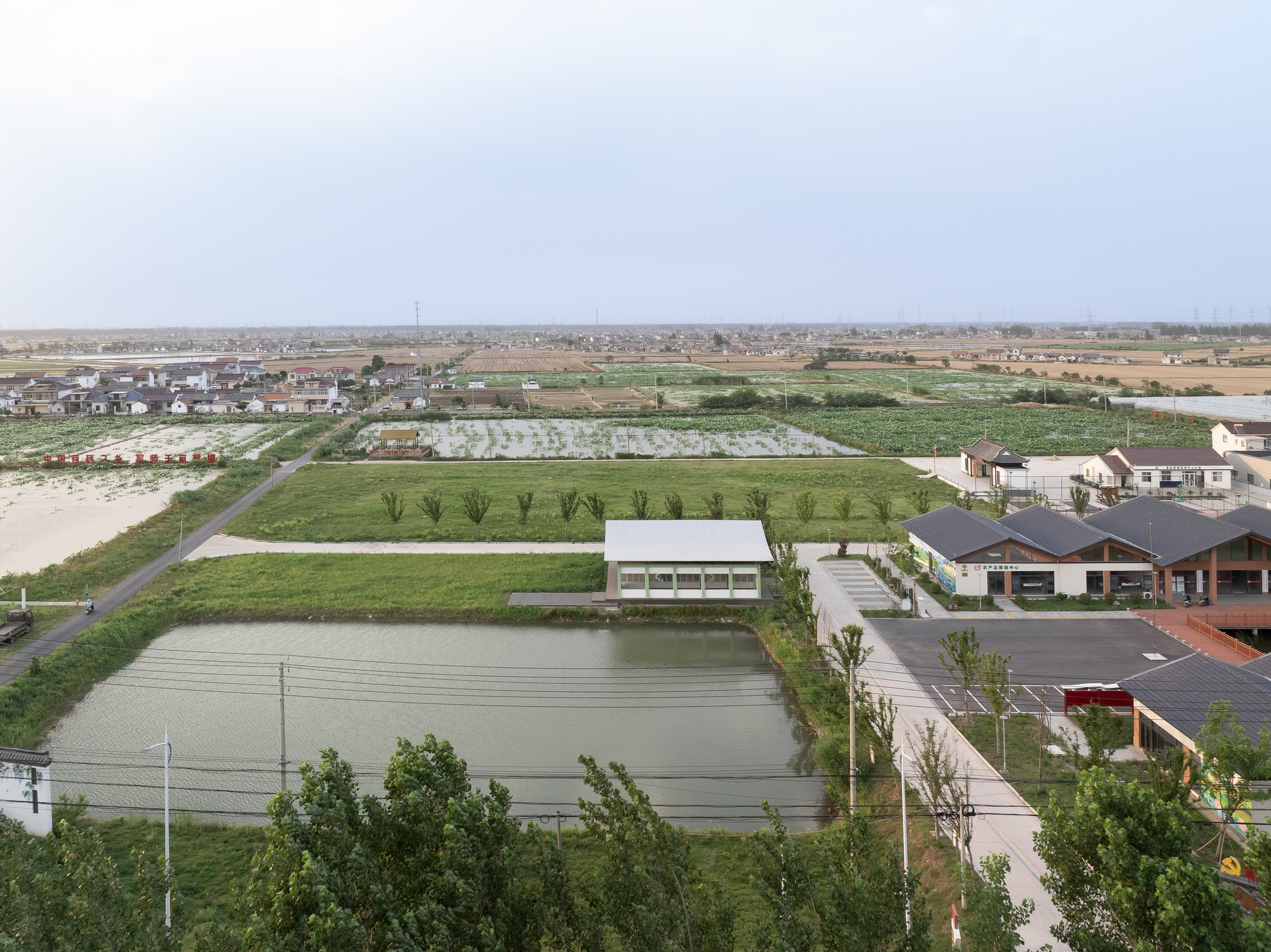 Aerial view of the white pavilion structure surrounded by agricultural fields and retention ponds