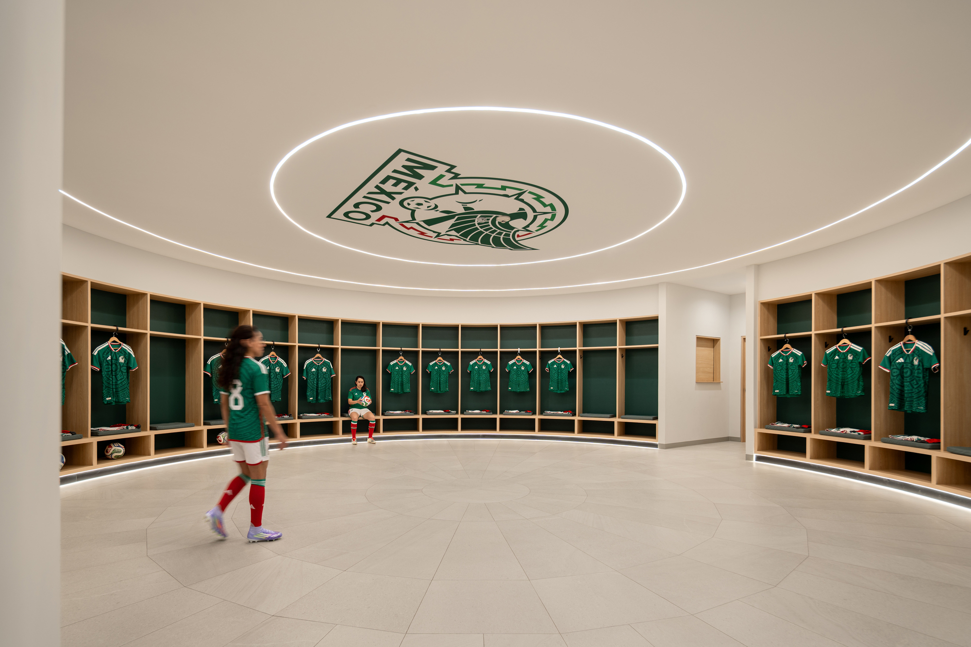 Circular locker room with curved wood cubbies and recessed ring lighting in the ceiling above