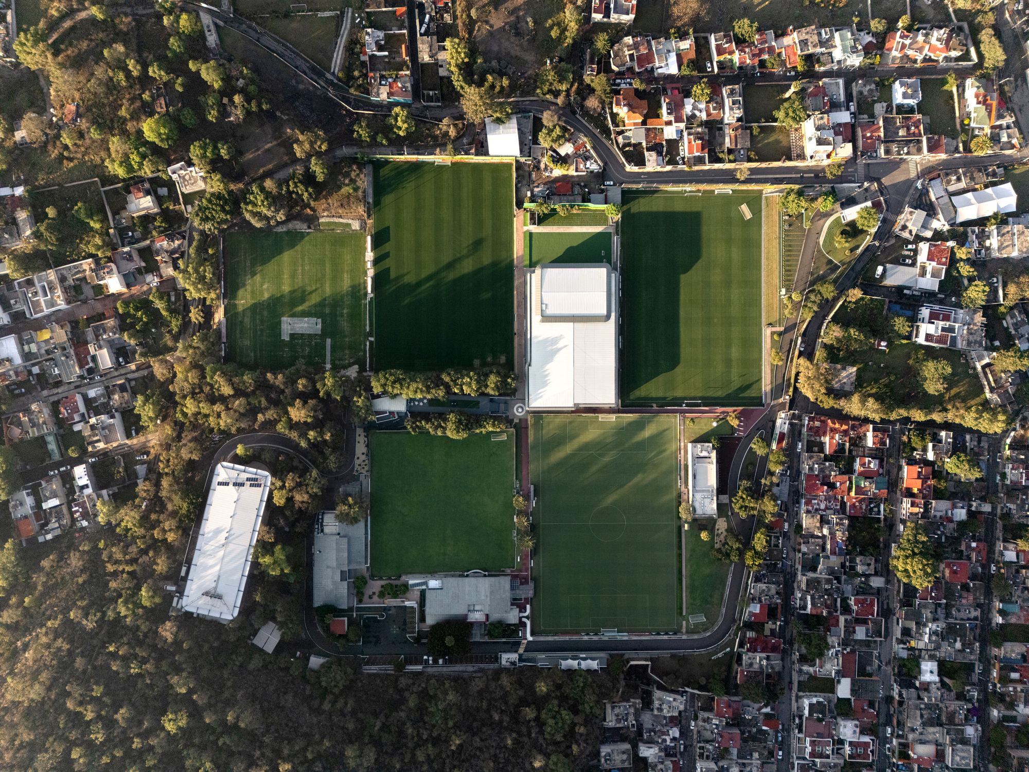 Aerial view of a sports complex with multiple playing fields surrounded by residential neighborhoods and trees