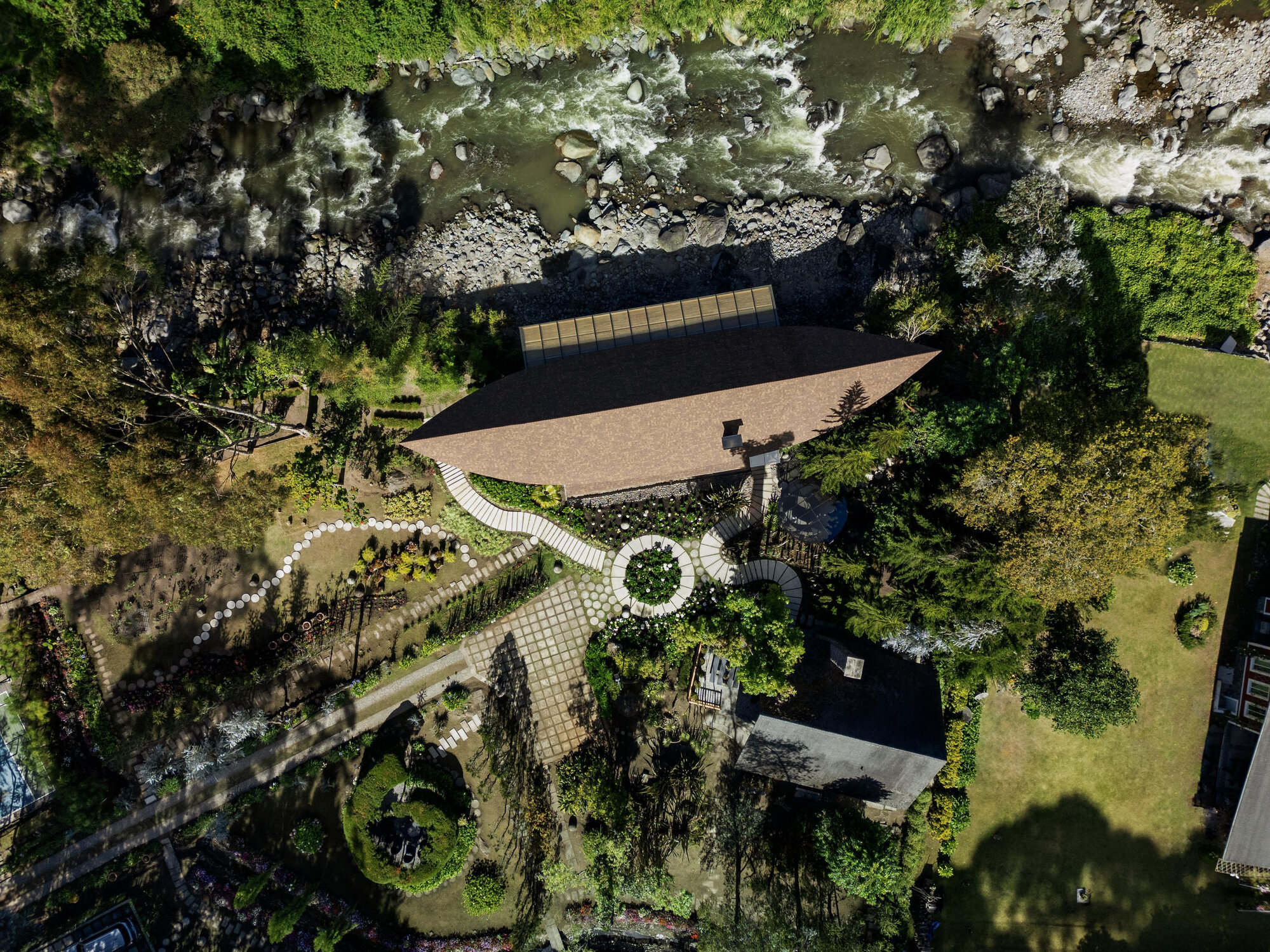 Aerial view of garden layout with pathways, pavilion, river edge and circular planted feature