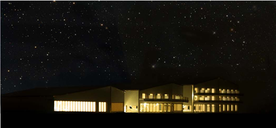 Illuminated winery volumes forming a nighttime landmark.