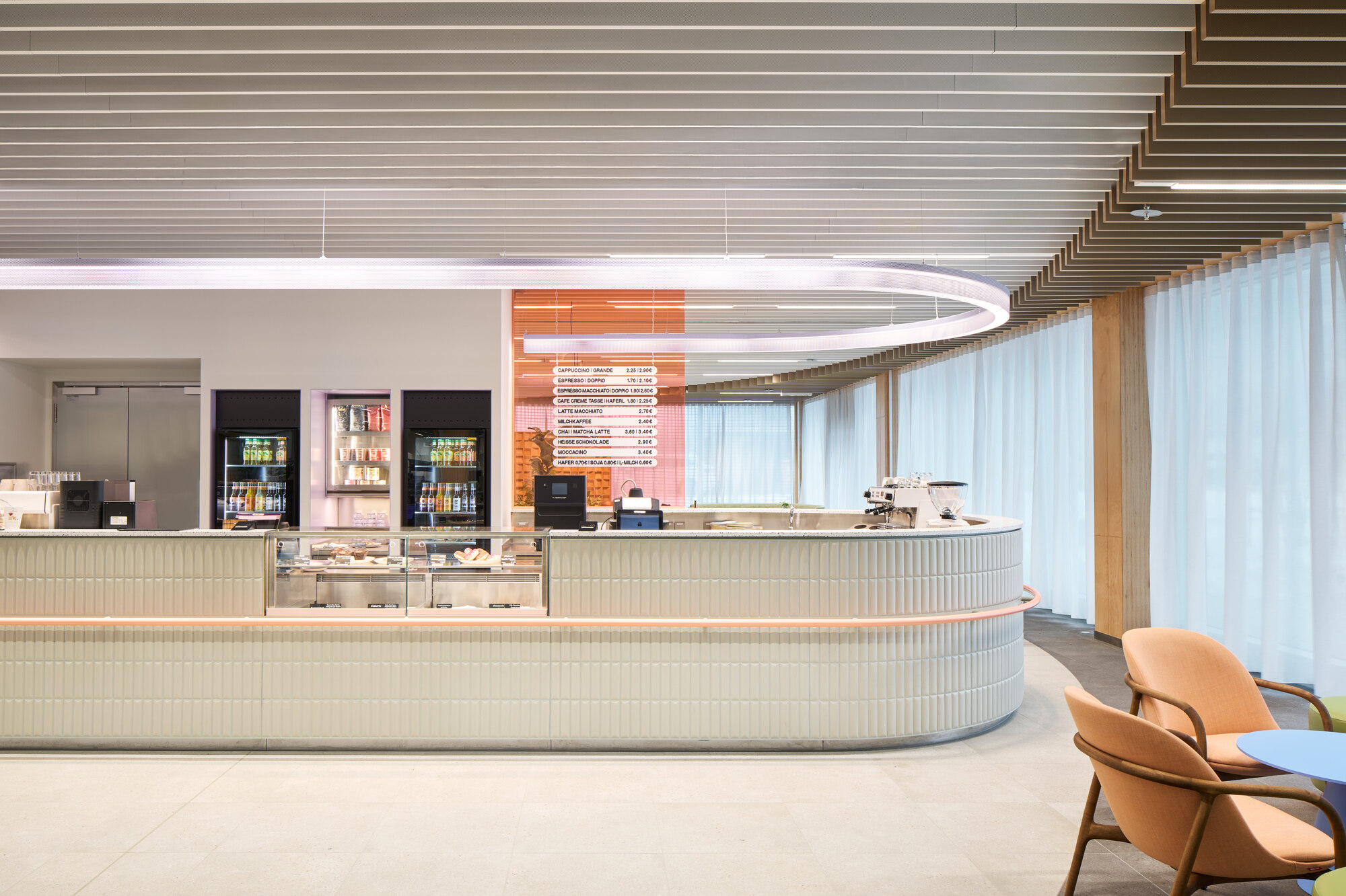 Curved service counter with fluted paneling beneath a ribbed timber ceiling and white curtain wall