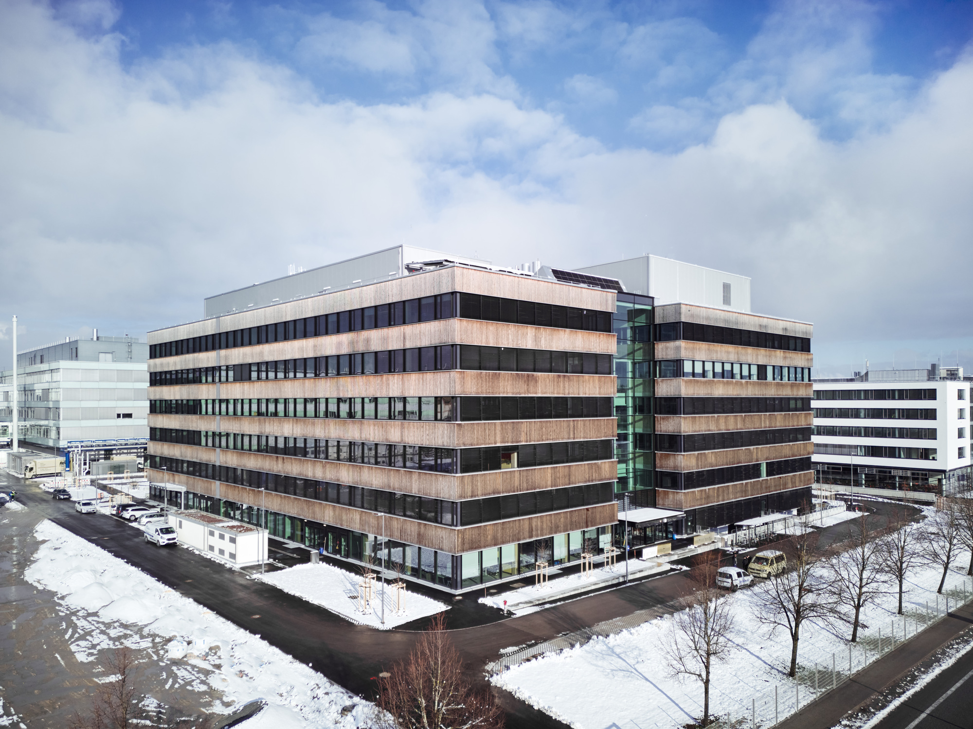 Aerial view of the horizontally banded facade with alternating copper and dark panels in winter