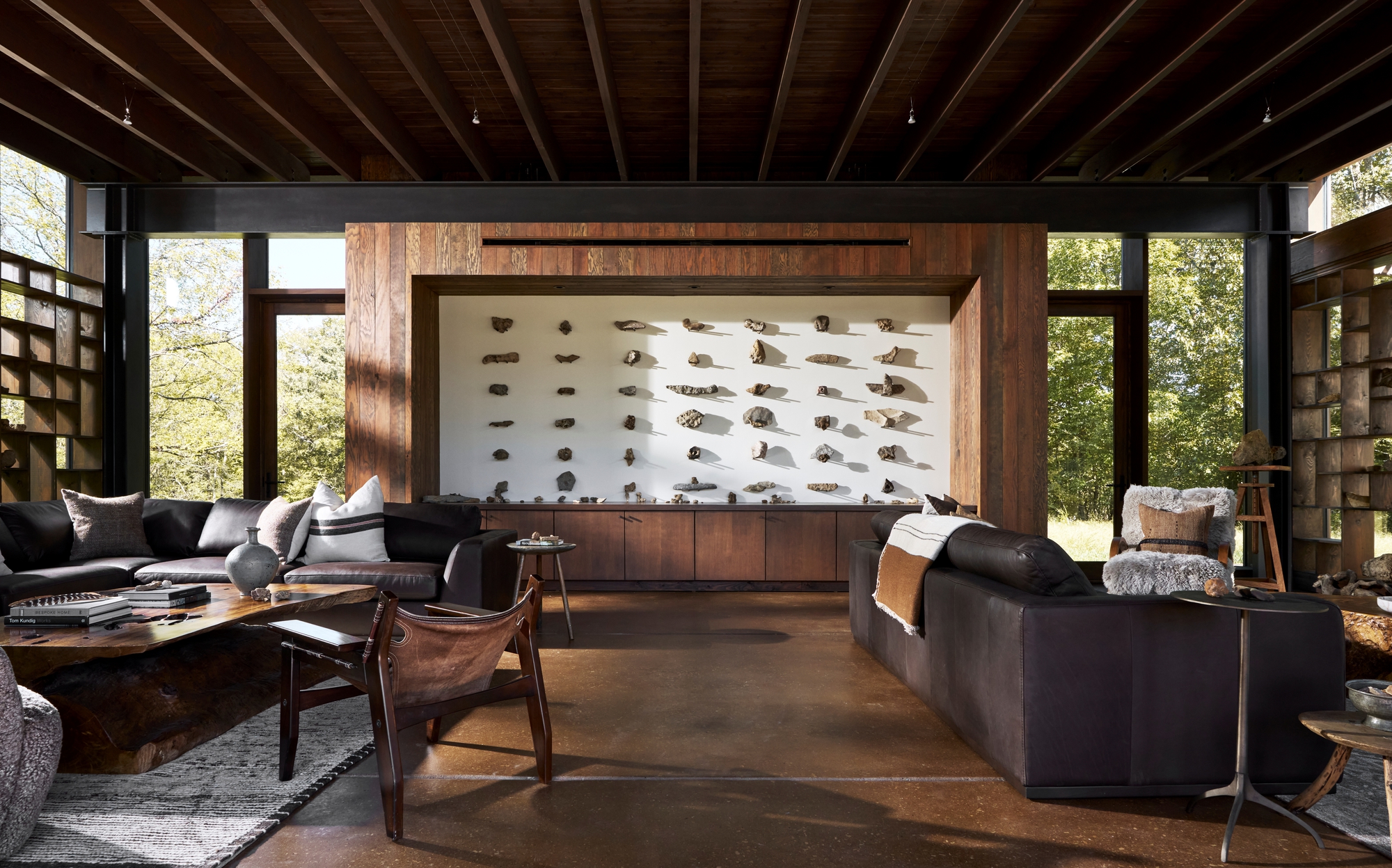 Living room with exposed timber ceiling beams and a backlit rock specimen display framed in walnut