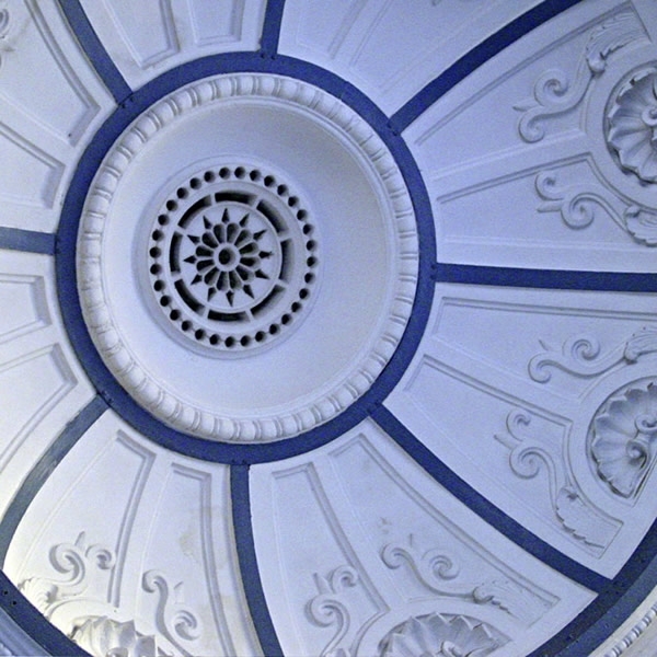 Ceiling detail with radiating plaster panels and central ventilation rosette surrounded by molded ornament
