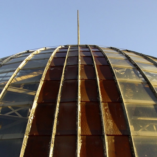 Upward view of the curved glass and metal dome with vertical ribs and central spire