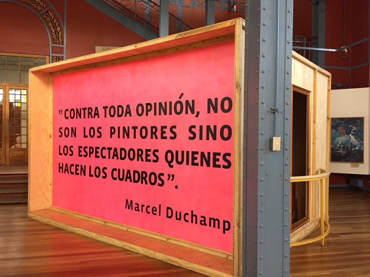 Freestanding timber-framed exhibition panel with coral-colored graphics beside a painted steel column