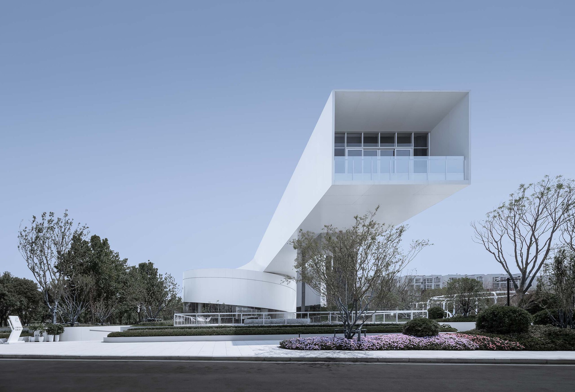 Side elevation showing the cantilevered upper volume with recessed glazing and planted landscape