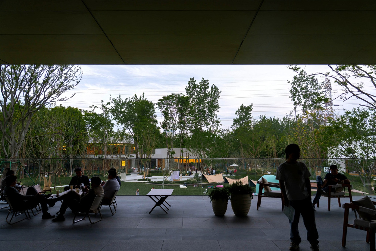Covered terrace with visitors seated overlooking the park and distant buildings through trees