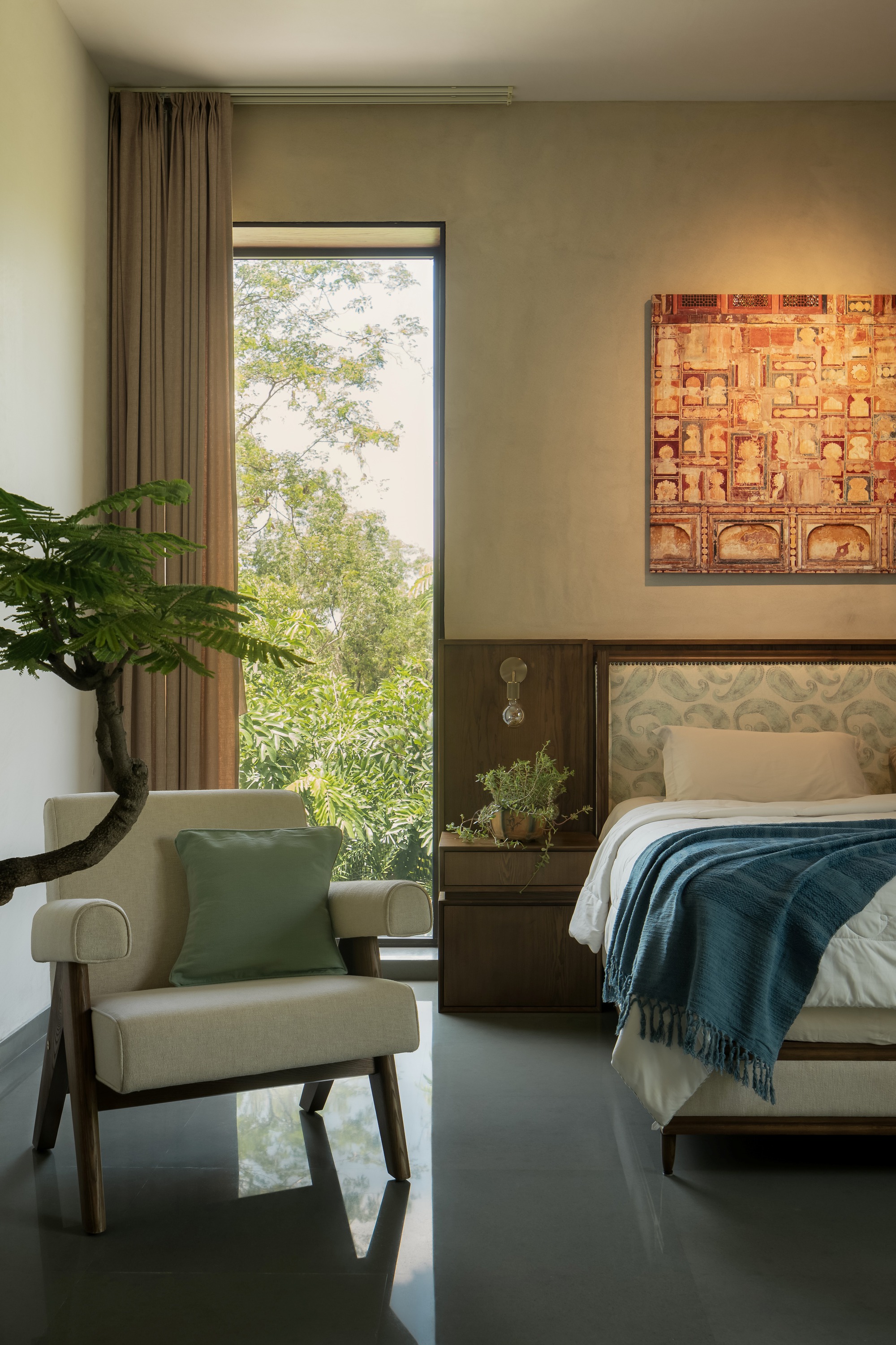 Bedroom with tall framed window to greenery and woven panel artwork above the timber headboard