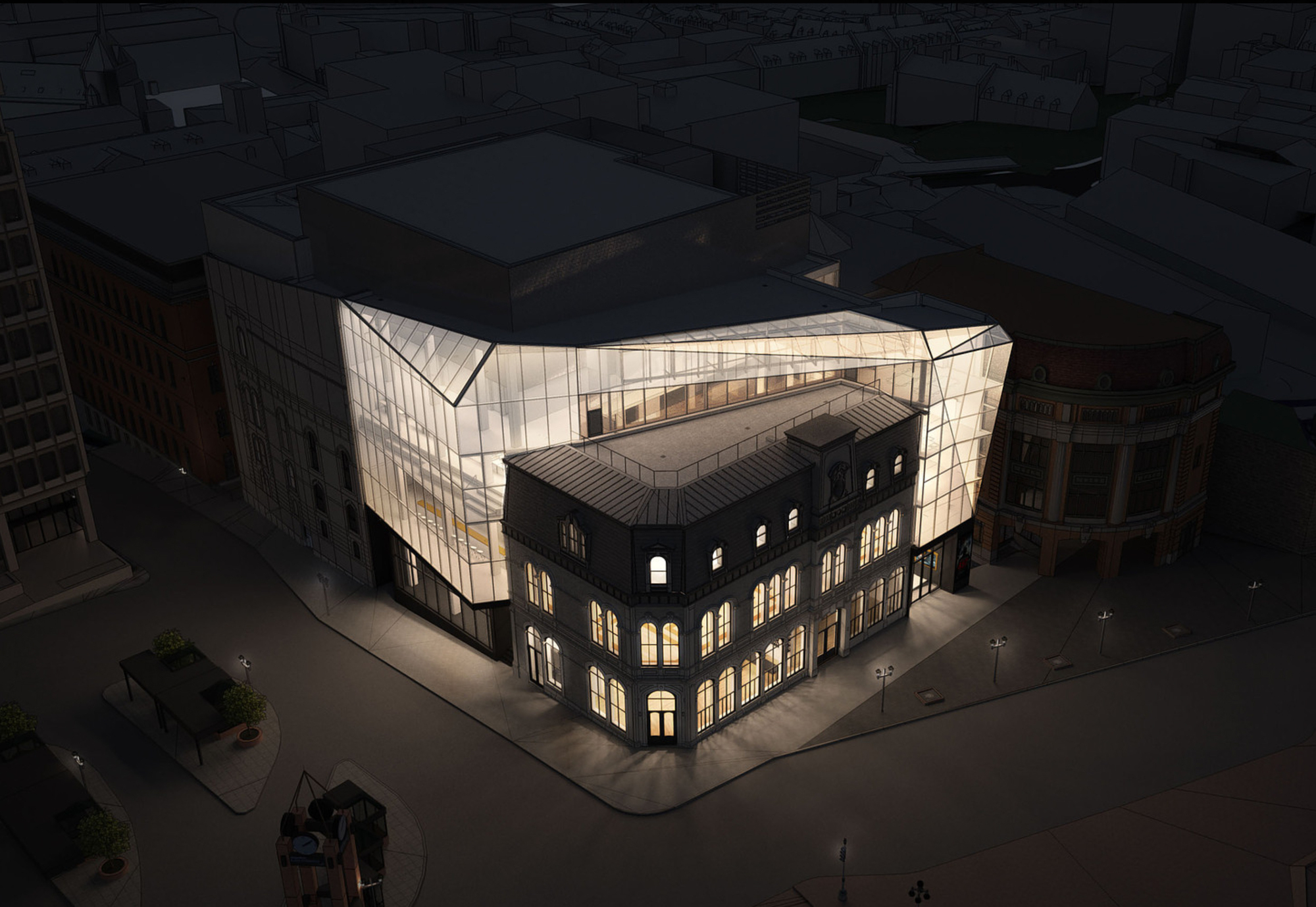 Aerial view of a glowing glass addition wrapping a historic masonry corner building at dusk