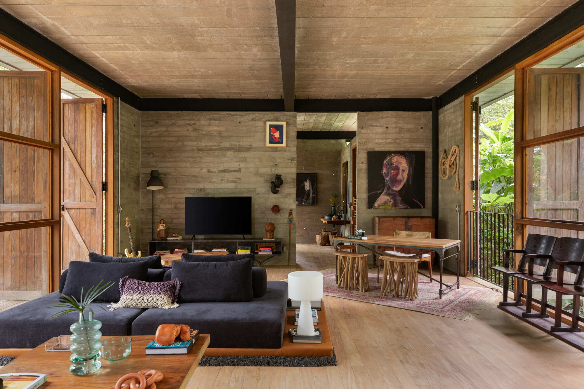 Living room with board-formed concrete wall and timber sliding doors flanking the main seating area
