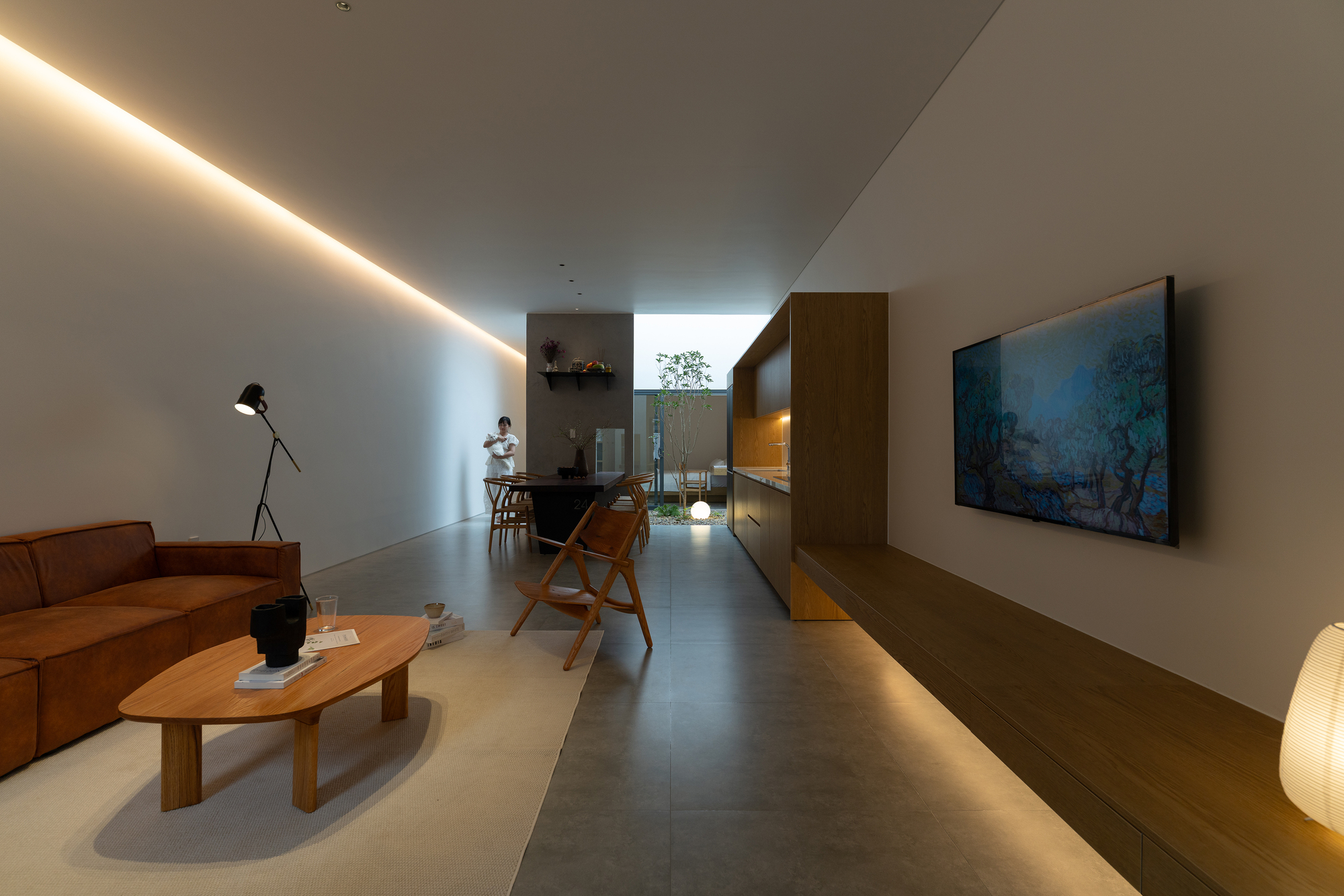Long interior corridor with cove lighting and view through to courtyard garden
