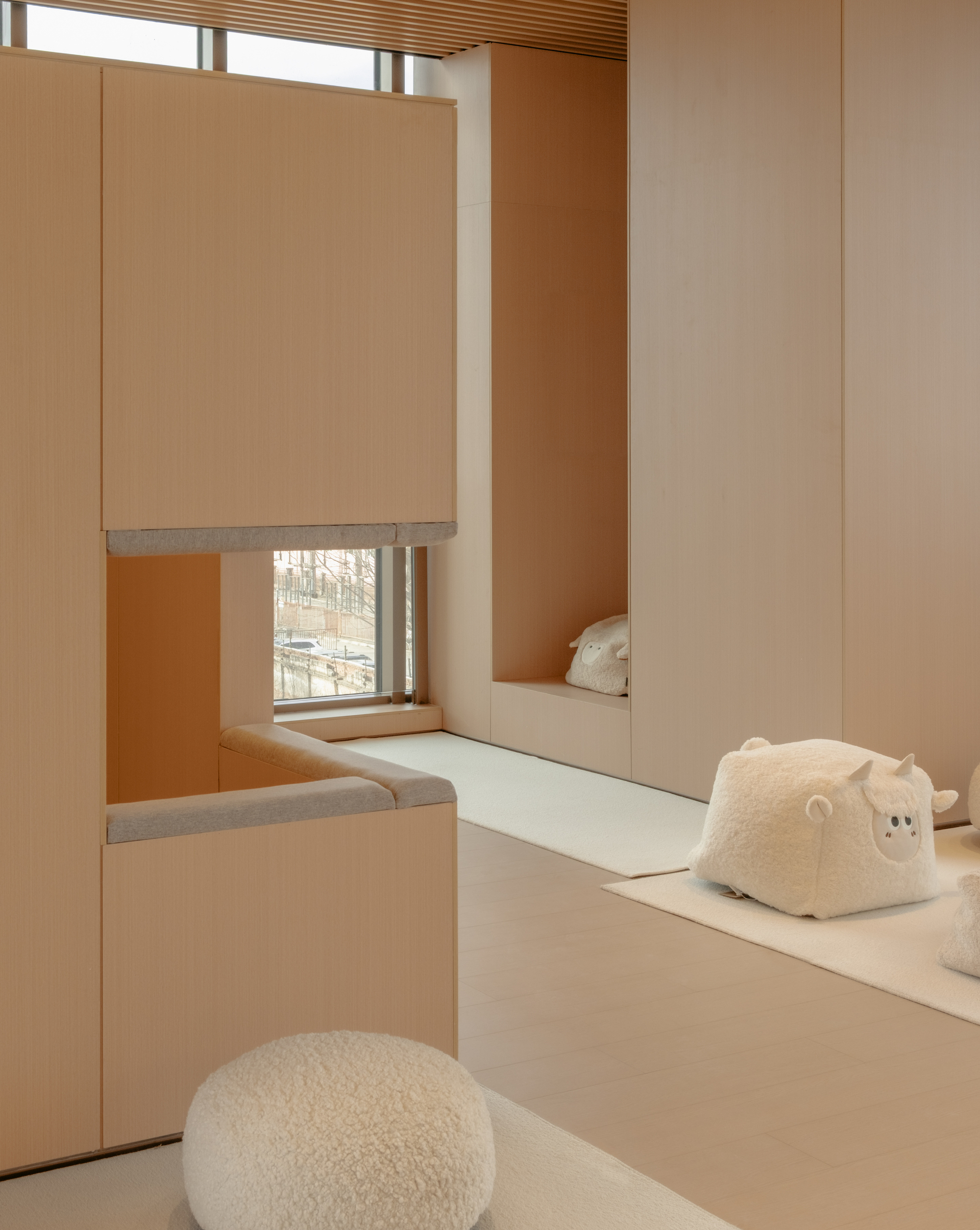 Corner nook with window seat, mirrored wall panels, and fleece cushions in afternoon light