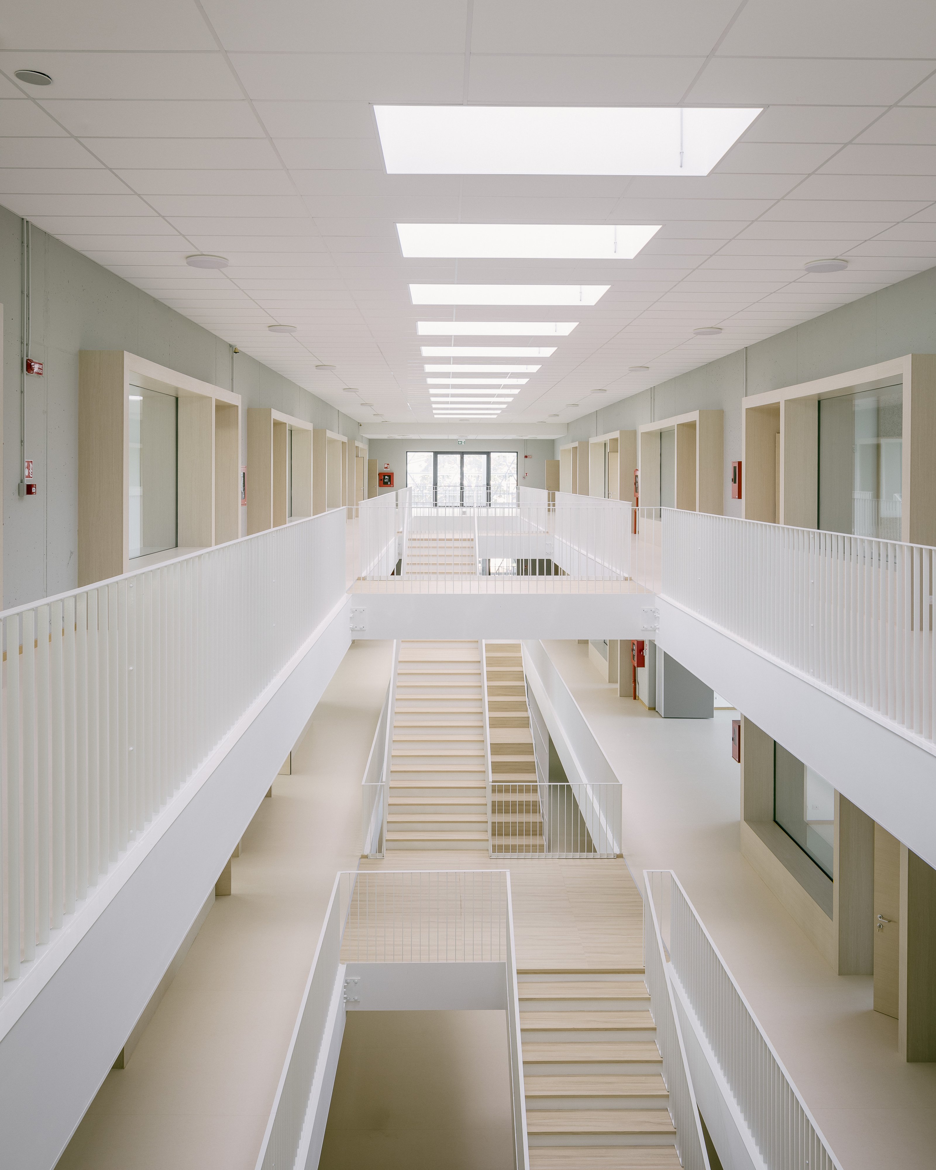 Galleries wrap the atrium, overlapping circulation and informal learning. Photo © Aldo Amoretti