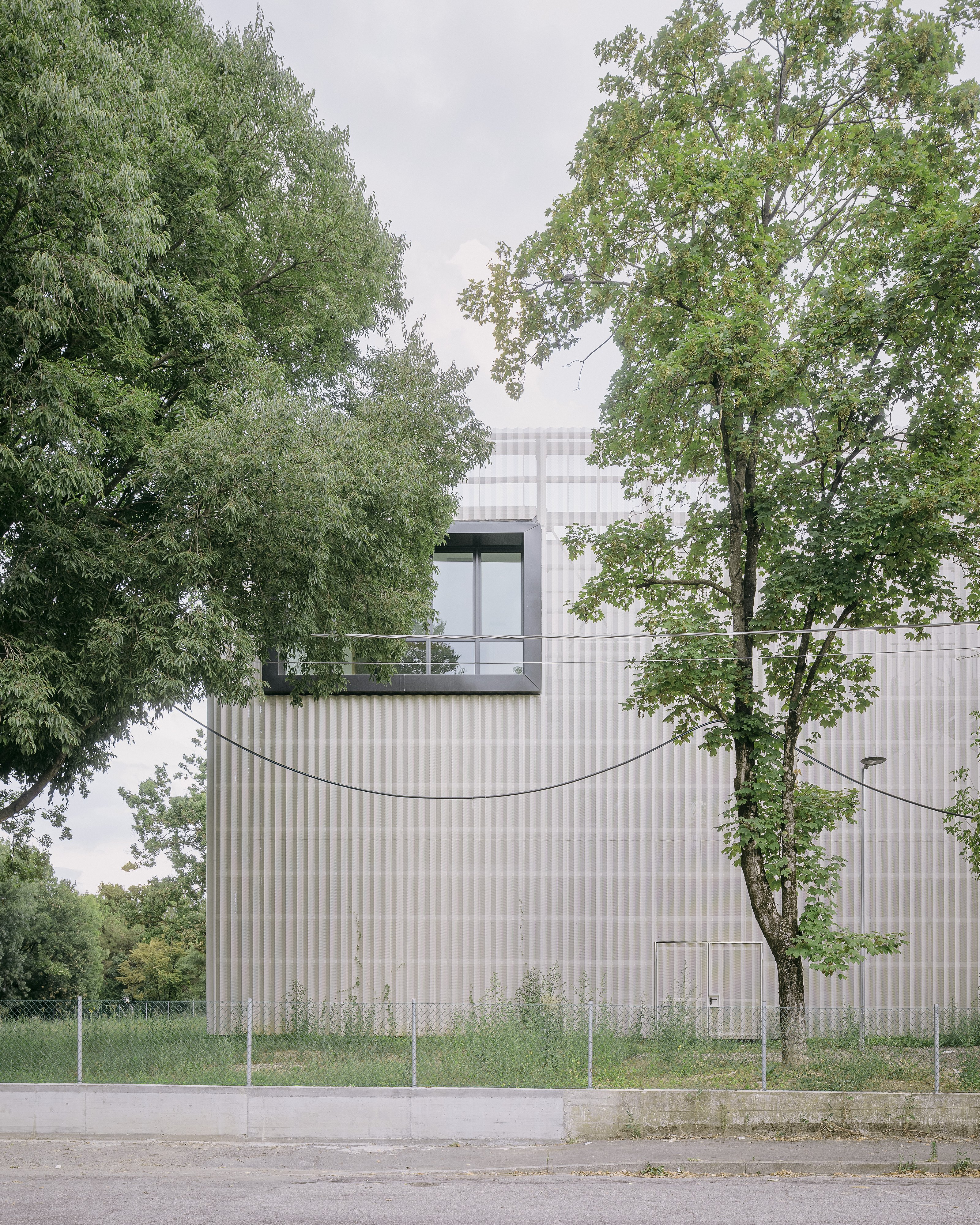 A large glazed "eye" in the façade marks a flexible workshop space. Photo © Aldo Amoretti