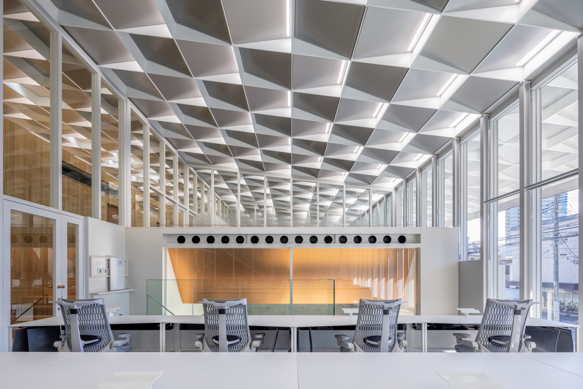 Interior meeting room with white geometric coffered ceiling and floor-to-ceiling glass walls